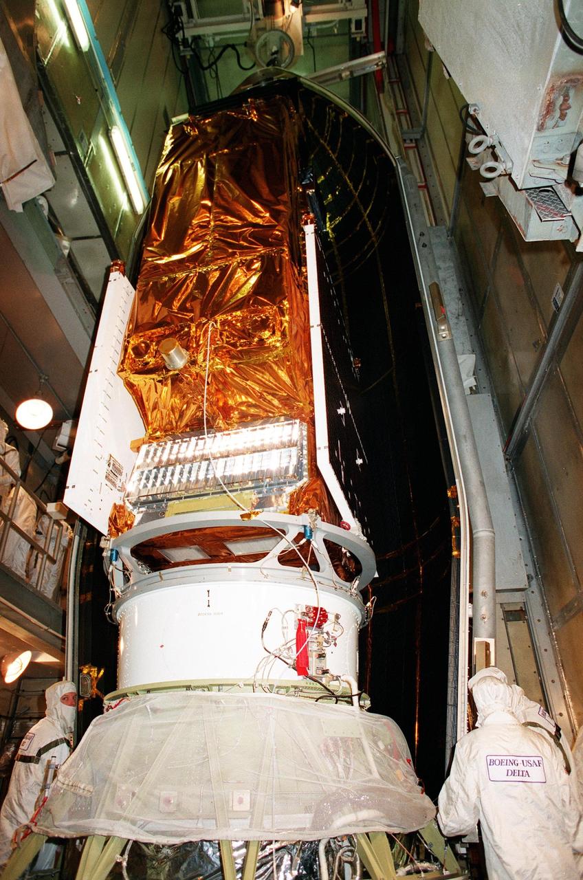 At Launch Pad 17A, Cape Canaveral Air Station, NASA's Far Ultraviolet Spectroscopic Explorer (FUSE) satellite (foreground) is partially covered by half of the fairing (behind it) that will protect it during launch. The satellite is scheduled for launch June 24 aboard a Boeing Delta II rocket. FUSE is designed to scour the cosmos for the fossil record of the origins of the universe hydrogen and deuterium. Scientists will use FUSE to study those elements to unlock the secrets of how galaxies evolve and to discover what the Universe was like when it was only a few minutes old
