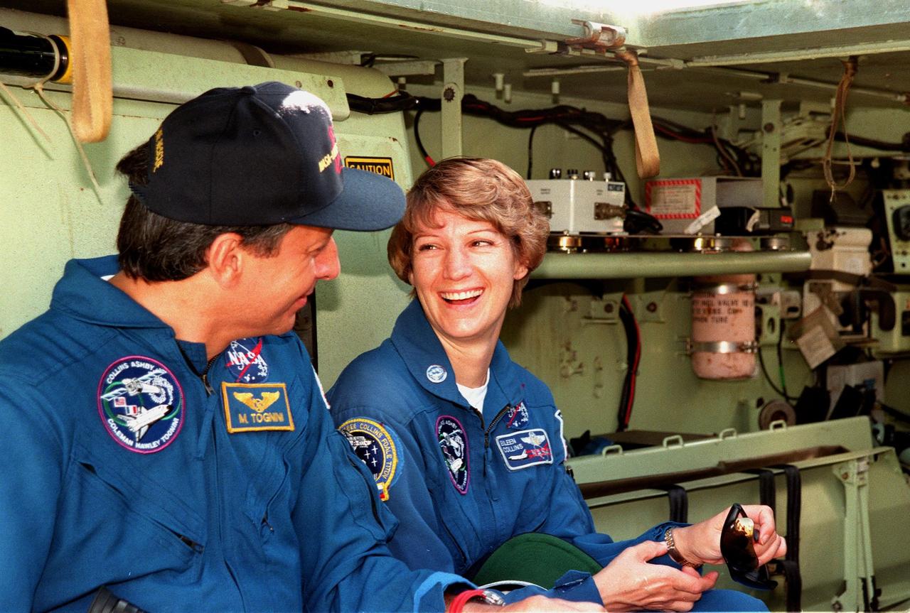 During emergency egress training inside an M-113 armored personnel carrier at the launch pad, Mission Specialist Michel Tognini of France and Commander Eileen M. Collins share a light moment. In preparation for their mission, the STS-93 crew are participating in Terminal Countdown Demonstration Test activities that also include a launch-day dress rehearsal culminating with a simulated main engine cut-off. Also at KSC are Pilot Jeffrey S. Ashby and Mission Specialists Steven A. Hawley (Ph.D.), and Catherine G. Coleman (Ph.D.). Collins is the first woman to serve as mission commander. Tognini represents the Centre National d'Etudes Spatiales (CNES). The primary mission of STS-93 is the release of the Chandra X-ray Observatory, which will allow scientists from around the world to obtain unprecedented X-ray images of exotic environments in space to help understand the structure and evolution of the universe. Chandra is expected to provide unique and crucial information on the nature of objects ranging from comets in our solar system to quasars at the edge of the observable universe. Since X-rays are absorbed by the Earth's atmosphere, space-based observatories are necessary to study these phenomena and allow scientists to analyze some of the greatest mysteries of the universe. The targeted launch date for STS-93 is no earlier than July 20 at 12:36 a.m. EDT from Launch Pad 39B