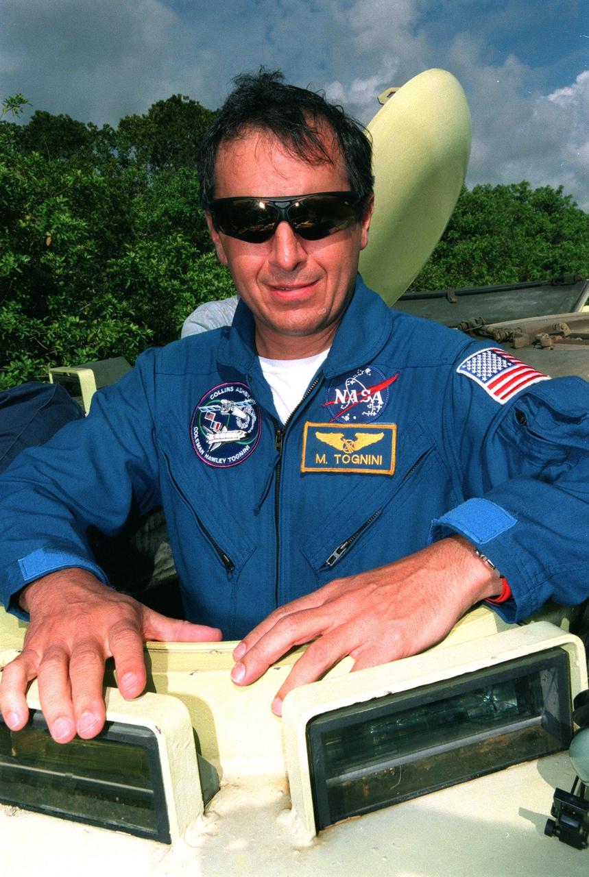 STS-93 Michel Tognini of France, who represents the Centre National d'Etudes Spatiales (CNES), pauses for the photographer before climbing into an M-113 armored personnel carrier at the launch pad to take part in emergency egress training. In preparation for their mission, the STS-93 crew are participating in Terminal Countdown Demonstration Test activities that also include a launch-day dress rehearsal culminating with a simulated main engine cut-off. Others in the crew are Commander Eileen M. Collins, Pilot Jeffrey S. Ashby, and Mission Specialists Steven A. Hawley (Ph.D.) and Catherine G. Coleman (Ph.D.). Collins is the first woman to serve as a mission commander. The primary mission of STS-93 is the release of the Chandra X-ray Observatory, which will allow scientists from around the world to obtain unprecedented X-ray images of exotic environments in space to help understand the structure and evolution of the universe. Chandra is expected to provide unique and crucial information on the nature of objects ranging from comets in our solar system to quasars at the edge of the observable universe. Since X-rays are absorbed by the Earth's atmosphere, space-based observatories are necessary to study these phenomena and allow scientists to analyze some of the greatest mysteries of the universe. The targeted launch date for STS-93 is no earlier than July 20 at 12:36 a.m. EDT from Launch Pad 39B