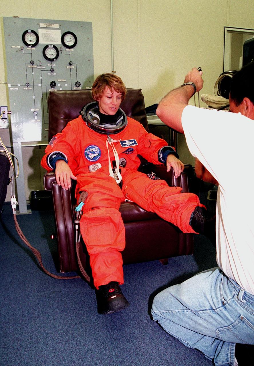 STS-93 Commander Eileen M. Collins has her launch and entry suit checked by a technician in the Operations and Checkout Bldg. In preparation for their mission, the STS-93 crew are participating in Terminal Countdown Demonstration Test activities that also include equipment check and a launch-day dress rehearsal culminating with a simulated main engine cut-off. Others in the crew participating are Pilot Jeffrey S. Ashby, and Mission Specialists Steven A. Hawley (Ph.D.), Catherine G. Coleman (Ph.D.) and Michel Tognini of France, who represents the Centre National d'Etudes Spatiales (CNES). Collins is the first woman to serve as a Shuttle commander. The primary mission of STS-93 is the release of the Chandra X-ray Observatory, which will allow scientists from around the world to obtain unprecedented X-ray images of exotic environments in space to help understand the structure and evolution of the universe. The targeted launch date for STS-93 is no earlier than July 20 at 12:36 a.m. EDT from Launch Pad 39B