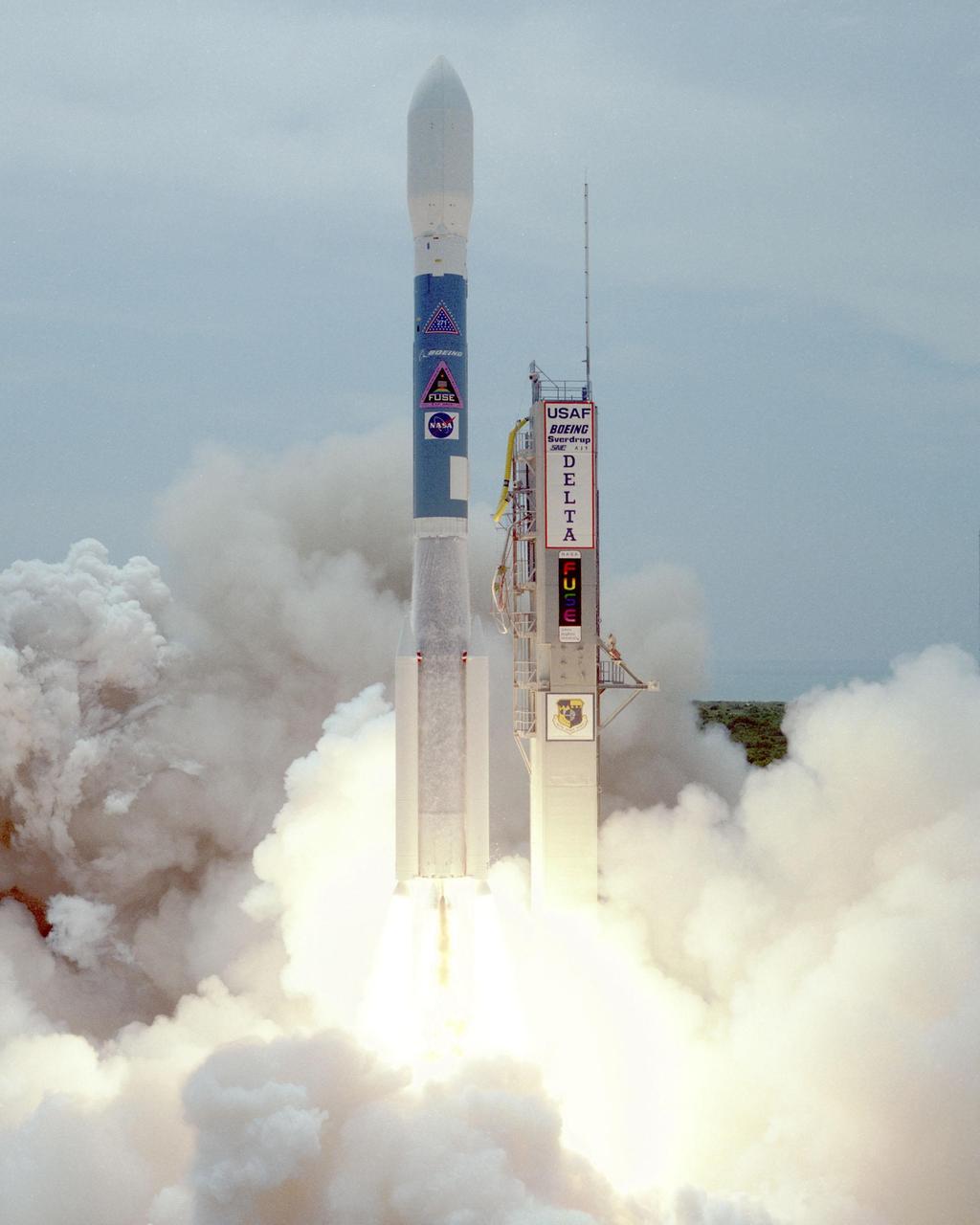 Clouds of smoke and steam billow around the Boeing Delta II rocket as it roars into the sky after liftoff at 11:44 a.m. EDT from Launch Pad 17A, Cape Canaveral Air Station. The rocket is carrying NASA's Far Ultraviolet Spectroscopic Explorer (FUSE) satellite. FUSE was developed to investigate the origin and evolution of the lightest elements in the universe hydrogen and deuterium. In addition, the FUSE satellite will examine the forces and process involved in the evolution of the galaxies, stars and planetary systems by investigating light in the far ultraviolet portion of the electromagnetic spectrum