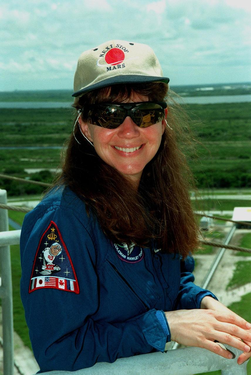 At the 195-foot level of Launch Pad 39B, STS-93 Mission Specialist Catherine G. Coleman (Ph.D.) takes in the view. The STS-93 crew members are at KSC to participate in a Terminal Countdown Demonstration Test, which familiarizes them with the mission, provides training in emergency exit from the orbiter and launch pad, and includes a launch-day dress rehearsal culminating with a simulated main engine cut-off. Other crew members are Commander Eileen M. Collins, Pilot Jeffrey S. Ashby, and Mission Specialists Steven A. Hawley (Ph.D.) and Michel Tognini of France, who represents the Centre National d'Etudes Spatiales (CNES). The primary mission of STS-93 is the release of the Chandra X-ray Observatory, which will allow scientists from around the world to obtain unprecedented X-ray images of exotic environments in space to help understand the structure and evolution of the universe. The targeted launch date for STS-93 is no earlier than July 20 at 12:36 a.m. EDT from Launch Pad 39B