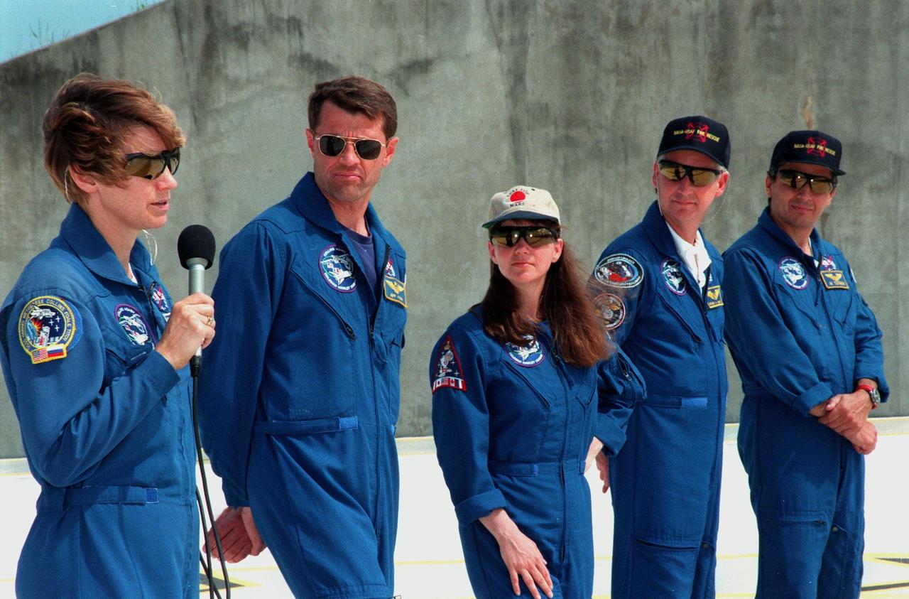 STS-93 Commander Eileen M. Collins (with microphone) talks to the press at a question and answer session at the slidewire basket area of Launch Pad 39B. She is joined by other crew members (from left) Pilot Jeffrey S. Ashby and Mission Specialists Catherine G. Coleman (Ph.D.), Steven A. Hawley (Ph.D.) and Michel Tognini of France, who represents the Centre National d'Etudes Spatiales (CNES). The crew members have been taking part in a Terminal Countdown Demonstration Test, which familiarizes them with the mission, provides training in emergency exit from the orbiter and launch pad, and includes a launch-day dress rehearsal culminating with a simulated main engine cut-off. The primary mission of STS-93 is the release of the Chandra X-ray Observatory, which will allow scientists from around the world to obtain unprecedented X-ray images of exotic environments in space to help understand the structure and evolution of the universe. The targeted launch date for STS-93 is no earlier than July 20 at 12:36 a.m. EDT from Launch Pad 39B
