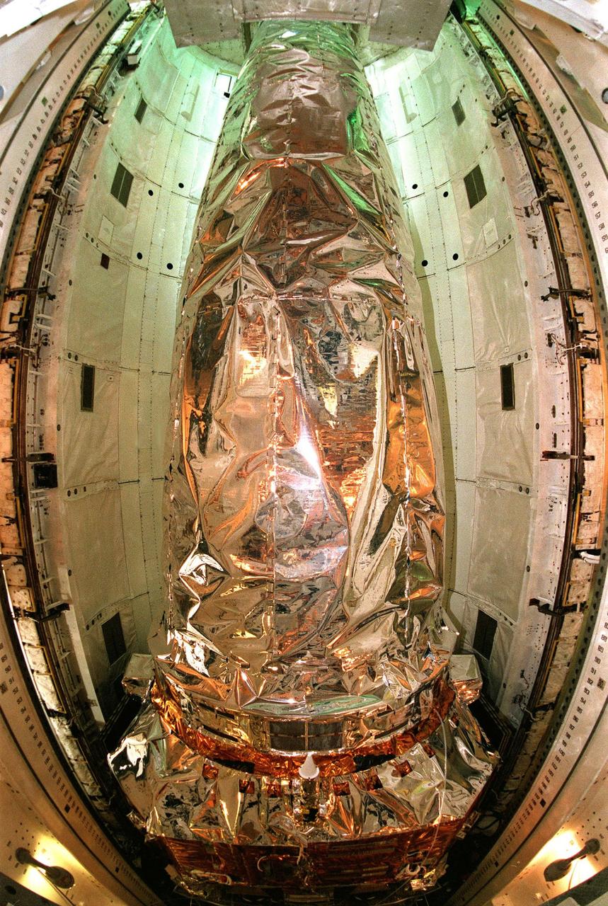 In this fish-eye view, the Chandra X-ray Observatory rests inside the payload bay of the orbiter Columbia. Chandra is the primary payload on mission STS-93, scheduled to launch no earlier than July 20 aboard Space Shuttle Columbia. The world's most powerful X-ray telescope, Chandra will allow scientists from around the world to see previously invisible black holes and high-temperature gas clouds, giving the observatory the potential to rewrite the books on the structure and evolution of our universe