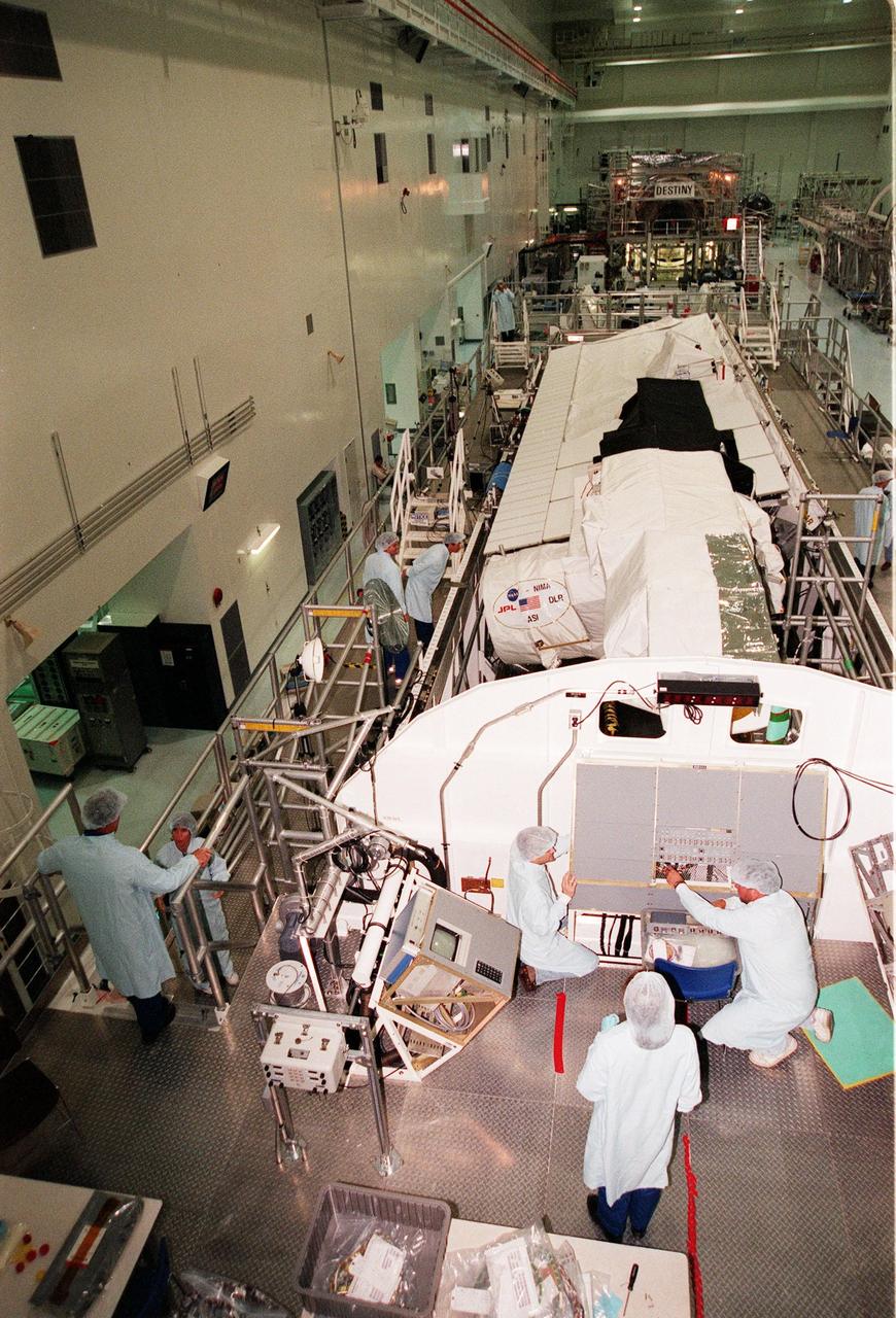 In the Space Station Processing Facility, STS-99 crew members inspect the Shuttle Radar Topography Mission (SRTM), the payload for their mission. At left is Commander Kevin R. Kregel talking to Mission Specialist Janice Voss (Ph.D.); and Mission Specialists Gerhard Thiele of Germany and Mamoru Mohri of Japan farther back. In the foreground (back to camera) is Mission Specialist Janet Lynn Kavandi (Ph.D.). The final crew member (not shown) is Pilot Dominic L. Pudwill Gorie. Thiele represents the European Space Agency and Mohri represents the National Space Agency of Japan. An international project spearheaded by the National Imagery and Mapping Agency and NASA, with participation of the German Aerospace Center DLR, the SRTM consists of a specially modified radar system that will gather data for the most accurate and complete topographic map of the Earth's surface that has ever been assembled. SRTM will make use of radar interferometry, wherein two radar images are taken from slightly different locations. Differences between these images allow for the calculation of surface elevation, or change. The SRTM hardware will consist of one radar antenna in the shuttle payload bay and a second radar antenna attached to the end of a mast extended 60 meters (195 feet) out from the shuttle. STS-99 is scheduled to launch Sept. 16 at 8:47 a.m. from Launch Pad 39A