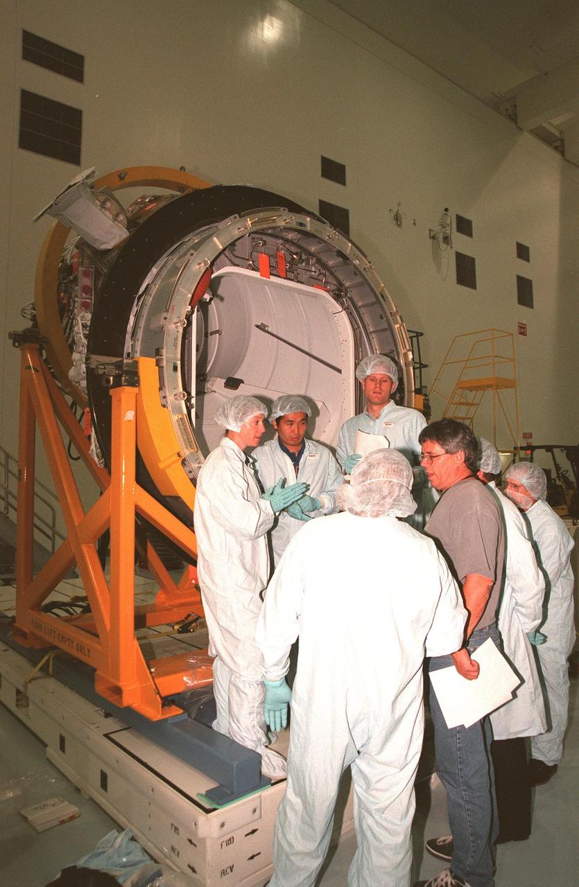 KENNEDY SPACE CENTER, FLA. -- In the Space Station Processing Facility, STS-92 crew members discuss the Pressurized Mating Adapter -3 (PMA-3) in the background with Boeing workers. From left are Pilot Pamela A. Melroy and Mission Specialists Koichi Wakata, who represents the National Space Development Agency of Japan (NASDA), and Peter J.K. "Jeff" Wisoff (Ph.D.). The STS-92 crew are taking part in a Leak Seal Kit Fit Check in connection with the PMA-3. Other crew members participating are Commander Brian Duffy and Mission Specialists Leroy Chiao (Ph.D.), Michael E. Lopez-Alegria and William Surles "Bill" McArthur Jr. The mission payload also includes an integrated truss structure (Z-1 truss). Launch of STS-92 is scheduled for Feb. 24, 2000