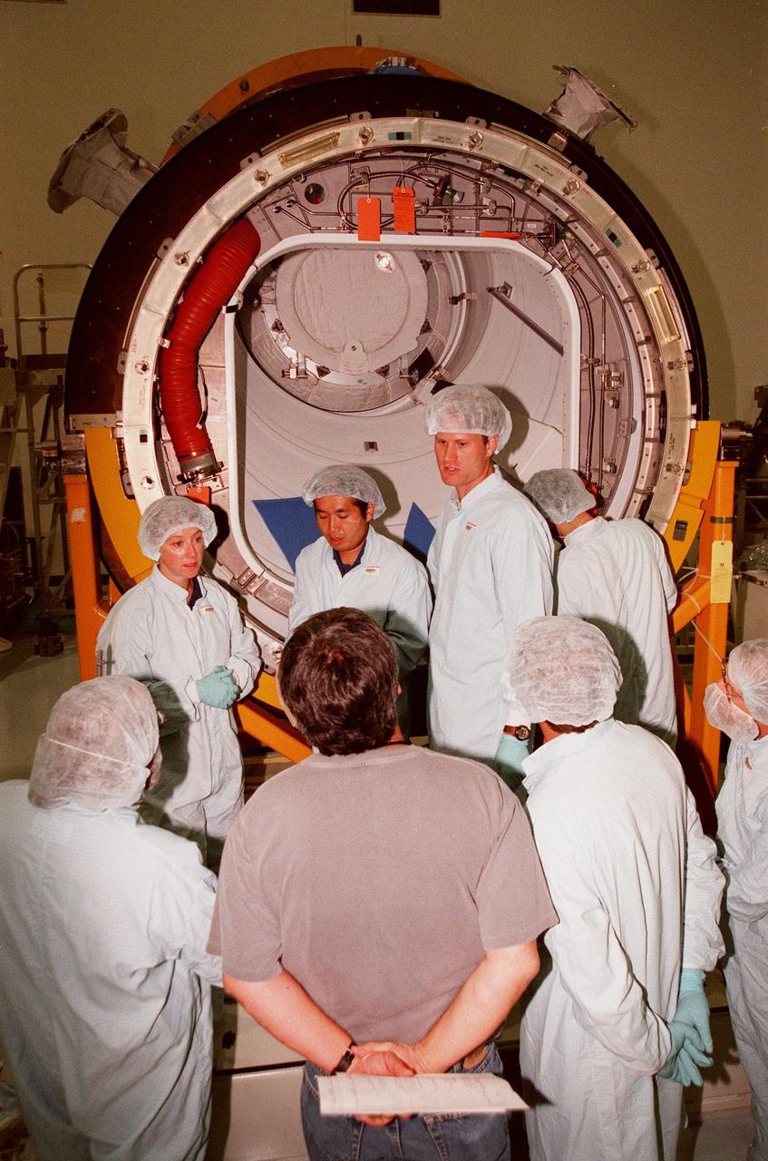 KENNEDY SPACE CENTER, FLA. -- In the Space Station Processing Facility, STS-92 crew members discuss the Pressurized Mating Adapter -3 (PMA-3), in the background, with Boeing workers. From left are Pilot Pamela A. Melroy and Mission Specialists Koichi Wakata, who represents the National Space Development Agency of Japan (NASDA), and Peter J.K. "Jeff" Wisoff (Ph.D.). The STS-92 crew are taking part in a Leak Seal Kit Fit Check in connection with the PMA-3. Other crew members participating are Commander Brian Duffy and Mission Specialists Leroy Chiao (Ph.D.), Michael E. Lopez-Alegria and William Surles "Bill" McArthur Jr. The mission payload also includes an integrated truss structure (Z-1 truss). Launch of STS-92 is scheduled for Feb. 24, 2000