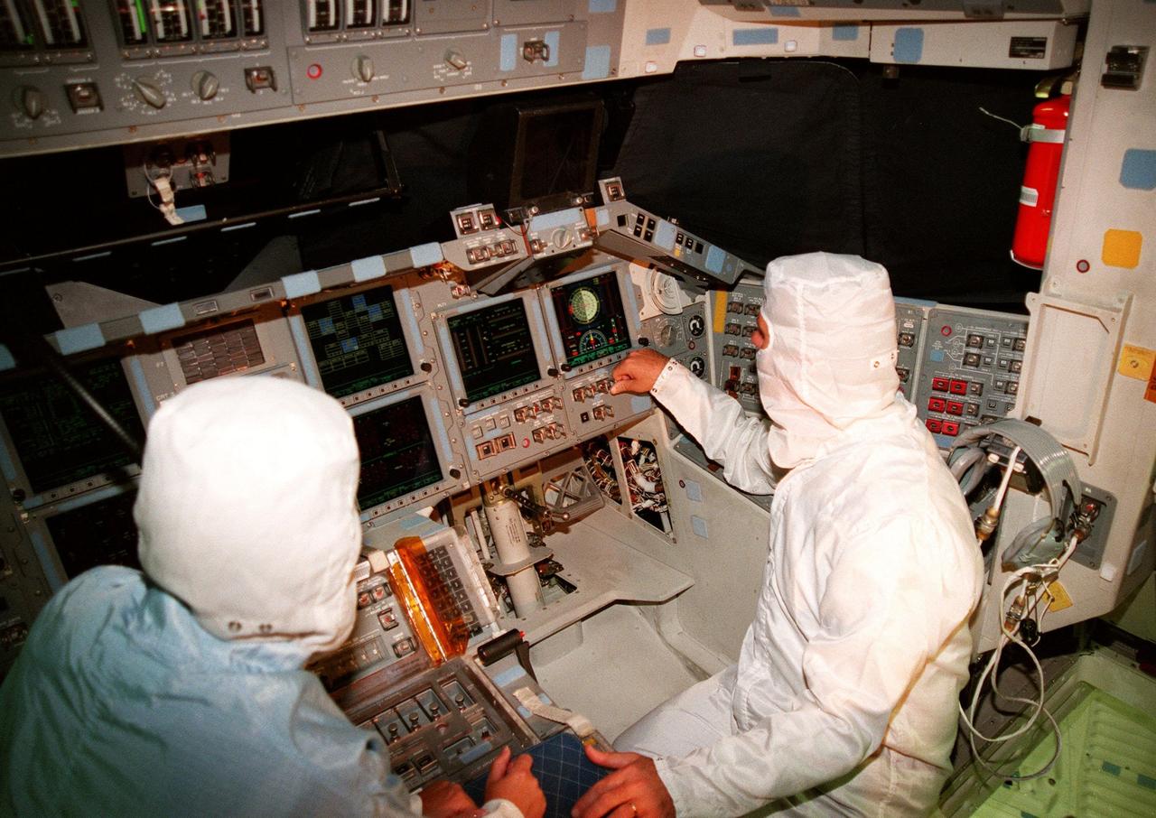 KENNEDY SPACE CENTER, FLA. -- In the cockpit of the orbiter Atlantis, which is in the Orbiter Processing Facility, U.S. Rep. Dave Weldon (right) looks at the newly installed Multifunction Electronic Display Subsystem (MEDS), known as the "glass cockpit." At left is Laural Patrick, a systems engineer with MEDS. Weldon is on the House Science Committee and vice chairman of the Space and Aeronautics Subcommittee. He was in Palmdale, Calif., when Atlantis underwent the modification and he wanted to see the final product. The full-color, flat-panel MEDS upgrade improves crew/orbiter interaction with easy-to-read, graphic portrayals of key flight indicators like attitude display and mach speed. The installation makes Atlantis the most modern orbiter in the fleet and equals the systems on current commercial jet airliners and military aircraft. Atlantis is scheduled to fly on mission STS-101 in early December