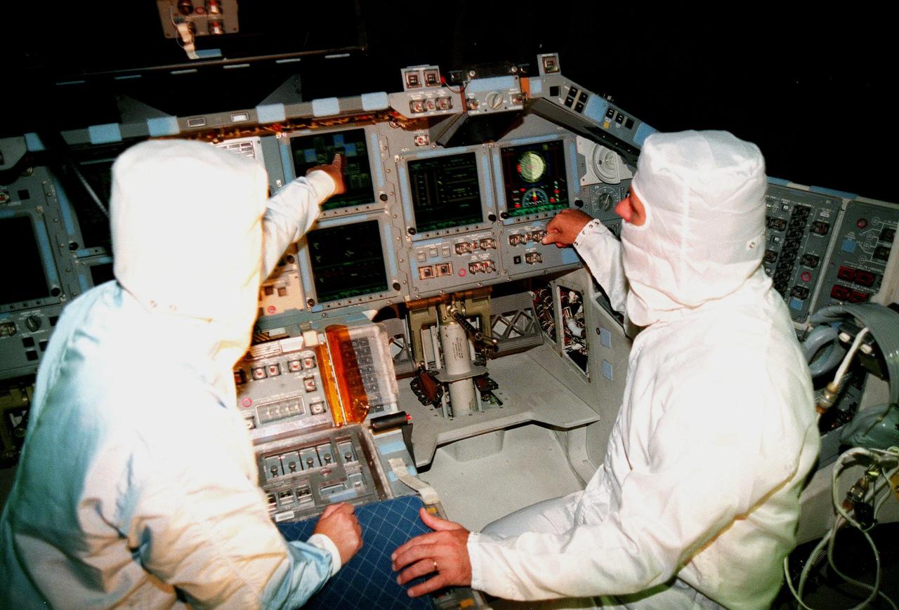 KENNEDY SPACE CENTER, FLA. -- In the cockpit of the orbiter Atlantis, which is in the Orbiter Processing Facility, Laural Patrick (left), a systems engineer with MEDS, points out a feature of the newly installed Multifunction Electronic Display Subsystem (MEDS), known as the "glass cockpit," to U.S. Rep. Dave Weldon. The congressman is on the House Science Committee and vice chairman of the Space and Aeronautics Subcommittee. He was in Palmdale, Calif., when Atlantis underwent the modification and he wanted to see the final product. The full-color, flat-panel MEDS upgrade improves crew/orbiter interaction with easy-to-read, graphic portrayals of key flight indicators like attitude display and mach speed. The installation makes Atlantis the most modern orbiter in the fleet and equals the systems on current commercial jet airliners and military aircraft. Atlantis is scheduled to fly on mission STS-101 in early December