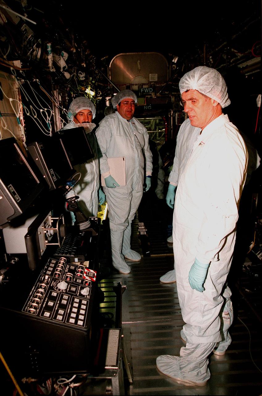 KENNEDY SPACE CENTER, FLA. -- Inside the U.S. Lab, called "Destiny," which is in the Space Station Processing Facility, U.S. Rep. Dave Weldon (right) looks over equipment. In the background (center) is Thomas R. "Randy" Galloway, with the Space Station Hardware Integration Office. Weldon is on the House Science Committee and vice chairman of the Space and Aeronautics Subcommittee. Destiny is scheduled to be launched on Space Shuttle Endeavour in early 2000. It will become the centerpiece of scientific research on the ISS, with five equipment racks aboard to provide essential functions for station systems, including high data-rate communications, and to maintain the station's orientation using control gyroscopes launched earlier. Additional equipment and research racks will be installed in the laboratory on subsequent Shuttle flights