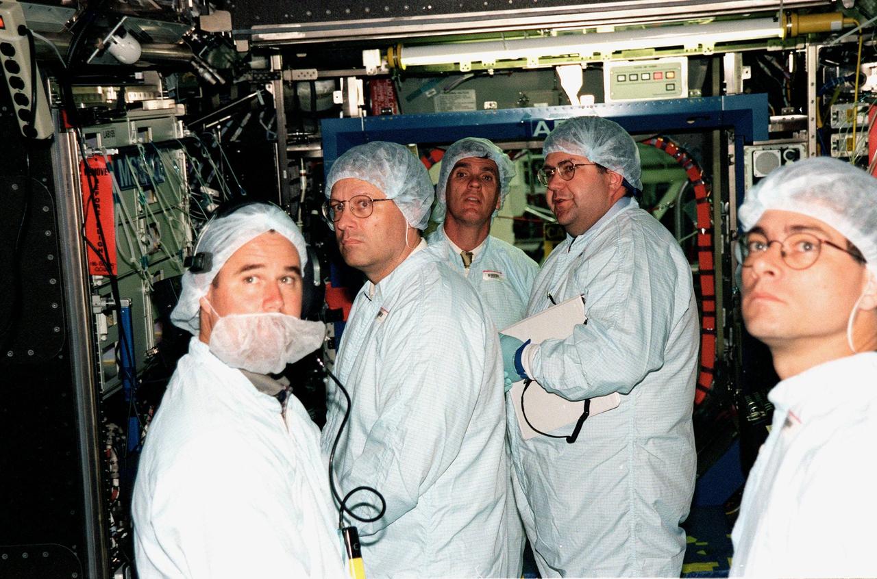 KENNEDY SPACE CENTER, FLA. -- In the Space Station Processing Facility, U.S. Rep. Dave Weldon (center) and his chief of staff Dana Gartzke (second from left) get a close-up look at the interior of the U.S. Lab, called "Destiny." Thomas R. "Randy" Galloway (second from right), with the Space Station Hardware Integration Office, helps with their familiarization of the equipment. They are joined (far left and right) by workers from Boeing. Weldon is on the House Science Committee and vice chairman of the Space and Aeronautics Subcommittee. Destiny is scheduled to be launched on Space Shuttle Endeavour in early 2000. It will become the centerpiece of scientific research on the ISS, with five equipment racks aboard to provide essential functions for station systems, including high data-rate communications, and to maintain the station's orientation using control gyroscopes launched earlier. Additional equipment and research racks will be installed in the laboratory on subsequent Shuttle flights