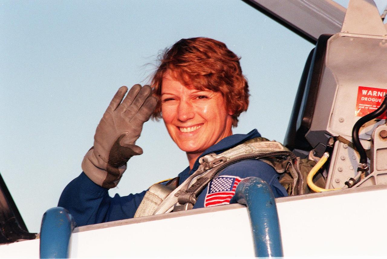 STS-93 Commander Eileen Collins waves to spectators after landing at Kennedy Space Center's Shuttle Landing Facility (SLF) aboard a T-38 jet aircraft. She and other crew members Pilot Jeffrey S. Ashby and Mission Specialists Steven A. Hawley (Ph.D.), Catherine G. "Cady" Coleman (Ph.D.) and Michel Tognini of France, with the Centre National d'Etudes Spatiales (CNES), are arriving for pre-launch activities. Collins is the first woman to serve as mission commander. This is her third Shuttle flight. The primary mission of STS-93 is the release of the Chandra X-ray Observatory, which will allow scientists from around the world to study some of the most distant, powerful and dynamic objects in the universe. The new telescope is 20 to 50 times more sensitive than any previous X-ray telescope and is expected to unlock the secrets of supernovae, quasars and black holes