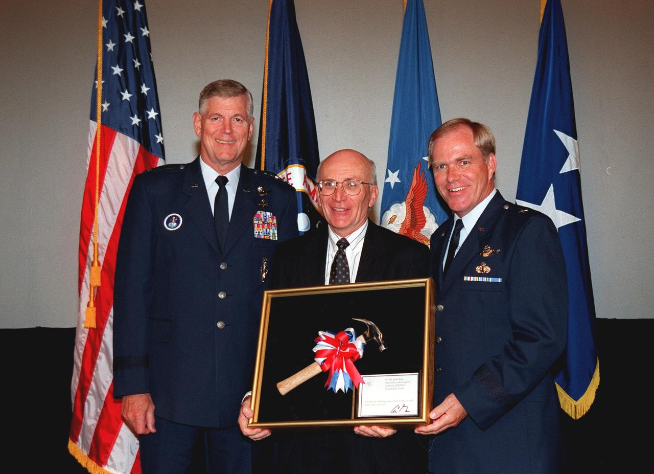 Commander of the Air Force Space Command, General Richard B. Myers (left) joins Ed Gormel (center) and Commander of the 45th Space Wing Brig. Gen. F. Randall Starbuck (right) after the presentation of the Hammer Award. The Hammer Award is Vice President Al Gore's special recognition of teams of federal employees who have made significant contributions in support of the principles of the National Partnership for Reinventing Government. Morley Winograd, director of the National Partnership for Reinventing Government, presented the award to the Joint Base Operations and Support Contract (J-BOSC) Source Evaluation Board (SEB). Gormel is a co-chair of the SEB. This Hammer Award acknowledges the accomplishments of a joint NASA and Air Force team that established the J-BOSC SEB. The team developed and implemented the acquisition strategy for establishing a single set of base operations and support service requirements for KSC, Cape Canaveral Air Station and Patrick Air Force Base