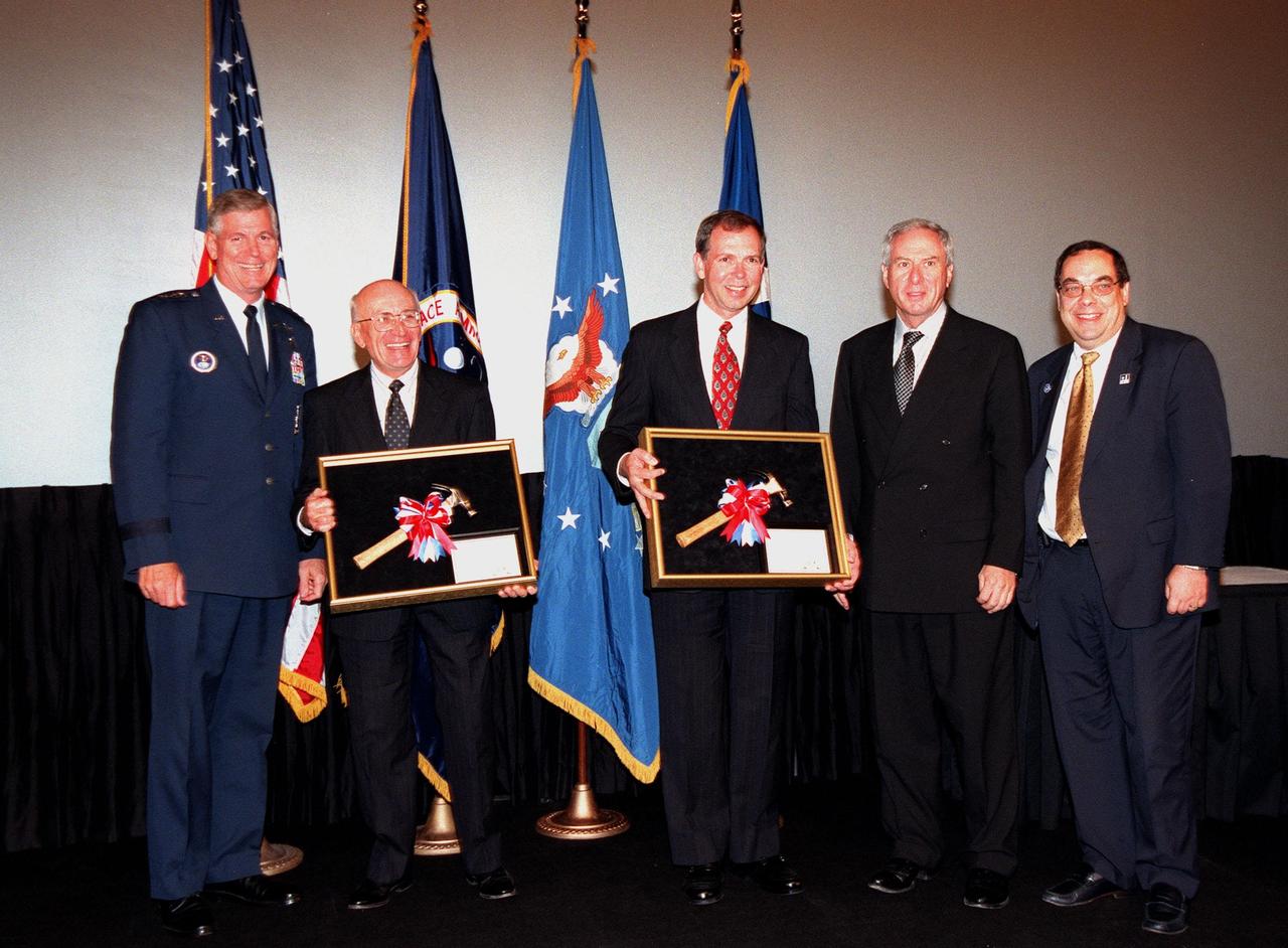 At a special presentation in the IMAX 2 Theater in the Kennedy Space Center Visitor Complex, the Hammer Award is presented to Kennedy Space Center and the 45th Space Wing. Present for the awards are (left to right) Commander of the Air Force Space Command General Richard B. Myers, Ed Gormel, Chris Fairey, NASA Administrator Daniel Goldin, and Director of the National Partnership for Reinventing Government, Morley Winograd, who presented the award. The Hammer Award is Vice President Al Gore's special recognition of teams of federal employees who have made significant contributions in support of the principles of the National Partnership for Reinventing Government. This Hammer Award acknowledges the accomplishments of a joint NASA and Air Force team that established the Joint Base Operations and Support Contract (J-BOSC) Source Evaluation Board (SEB). Gormel and Fairey are co-chairs of the SEB. The team developed and implemented the acquisition strategy for establishing a single set of base operations and support service requirements for KSC, Cape Canaveral Air Station and Patrick Air Force Base