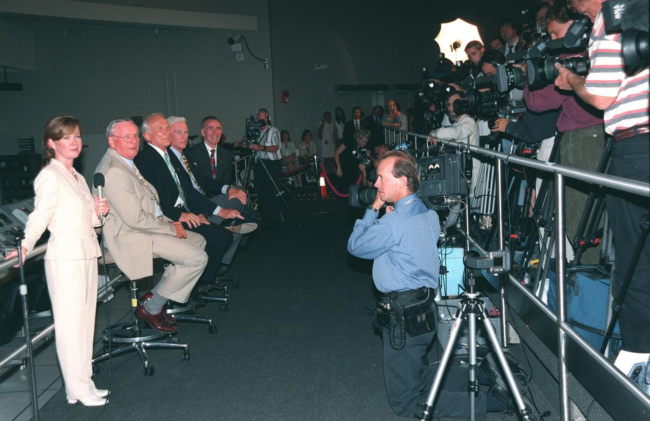 KENNEDY SPACE CENTER, FLA. -- Photographers and cameramen fill the stands of the Apollo/Saturn V Center for a press conference with former Apollo astronauts (seated, left to right) Neil A. Armstrong and Edwin "Buzz" Aldrin who flew on Apollo 11, the launch to the moon; Gene Cernan, who flew on Apollo 10 and 17; and Walt Cunningham, who flew on Apollo 7. At left is Lisa Malone, chief of KSC's Media Services branch, who monitored the session. The four astronauts were at KSC for the 30th anniversary of the Apollo 11 launch and moon landing, July 16 and July 20, 1969. Neil Armstrong was the first man to set foot on the moon