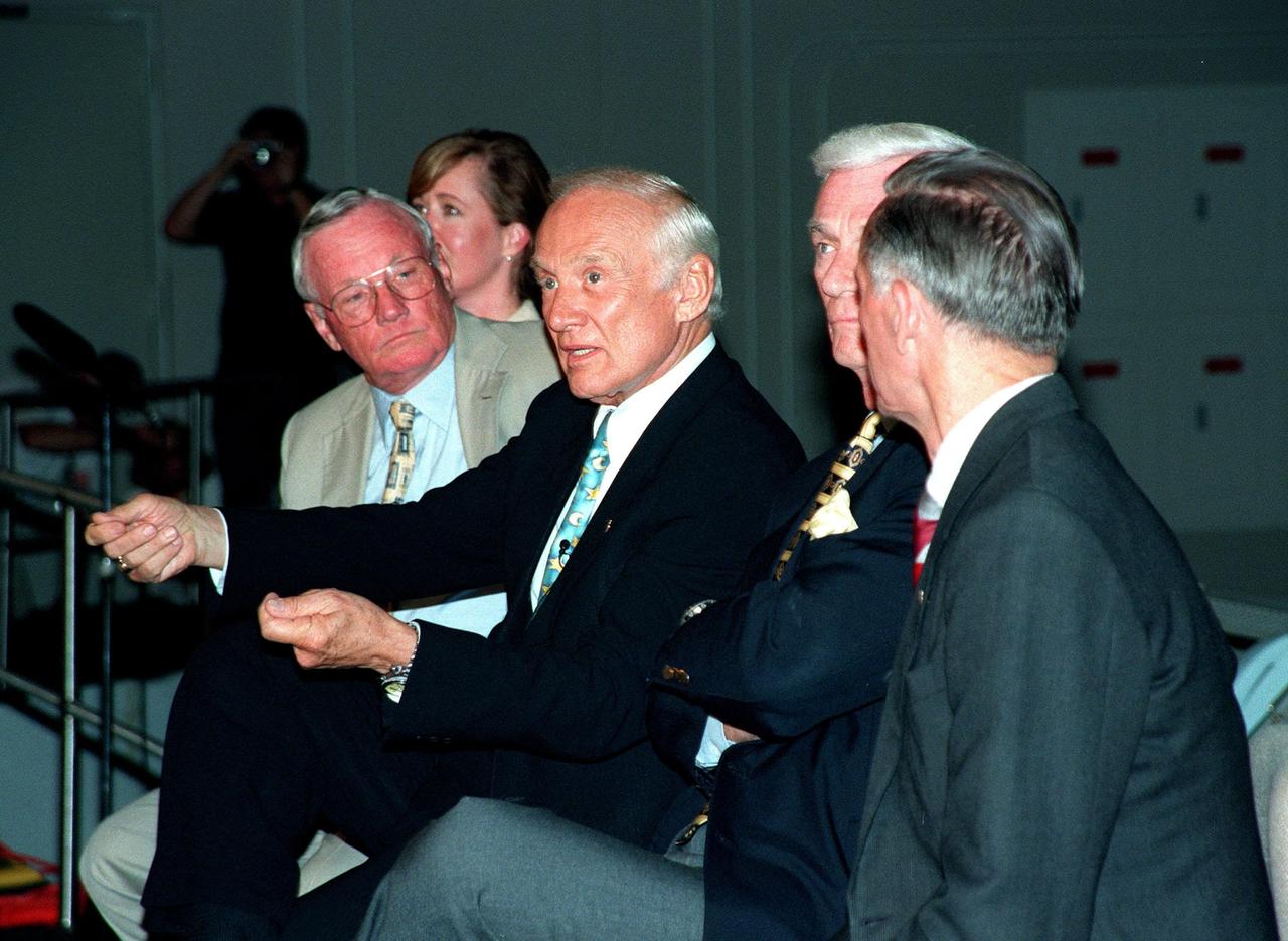 KENNEDY SPACE CENTER, FLA. -- At a media conference in the Apollo/Saturn V Center, former Apollo astronaut Edwin "Buzz" Aldrin, who flew on Apollo 11, the launch to the moon, demonstrates a point in his comment for the press. Joining him in the conference are other Apollo astronauts Neil A. Armstrong (left), who also flew on Apollo 11 and was the first man to set foot on the moon; Gene Cernan (right), who flew on Apollo 10 and 17; and Walt Cunningham (back to camera), who flew on Apollo 7. In the background is Lisa Malone, chief of KSC's Media Services branch, who monitored the session. The four astronauts were at KSC for the 30th anniversary of the Apollo 11 launch and moon landing, July 16 and July 20, 1969
