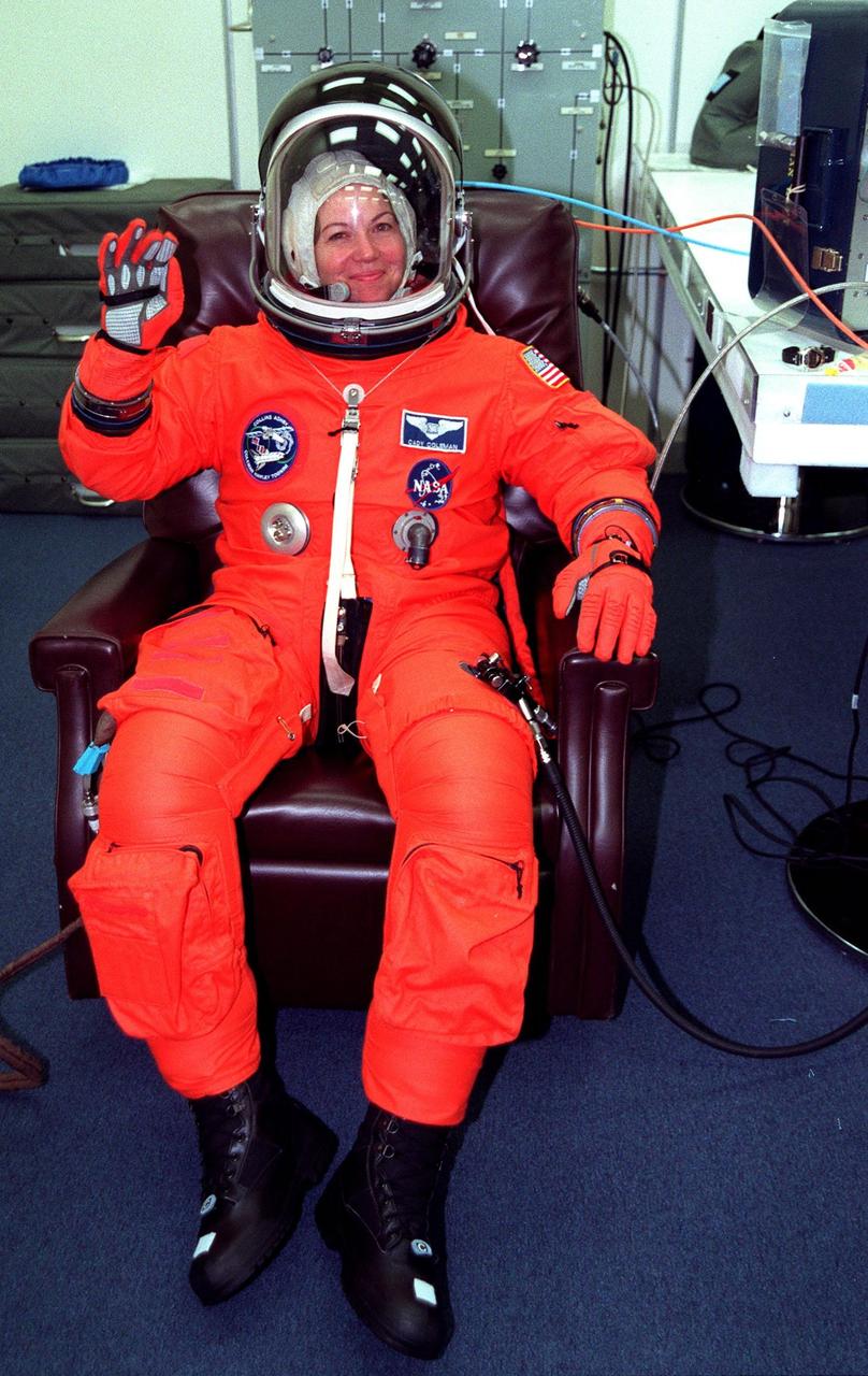 In the Operations and Checkout Building, STS-93 Mission Specialist Catherine G. Coleman (Ph.D.) waves after donning her launch and entry suit during final launch preparations. STS-93 is a five-day mission primarily to release the Chandra X-ray Observatory, which will allow scientists from around the world to study some of the most distant, powerful and dynamic objects in the universe. The new telescope is 20 to 50 times more sensitive than any previous X-ray telescope and is expected unlock the secrets of supernovae, quasars and black holes. The STS-93 crew numbers five: Commander Eileen M. Collins, Pilot Jeffrey S. Ashby, and Mission Specialists Stephen A. Hawley (Ph.D.), Coleman and Michel Tognini of France, who represents the Centre National d'Etudes Spatiales (CNES). Collins is the first woman to serve as commander of a shuttle mission. STS-93 is scheduled to lift off at 12:36 a.m. EDT July 20. The target landing date is July 24 at 11:30 p.m. EDT