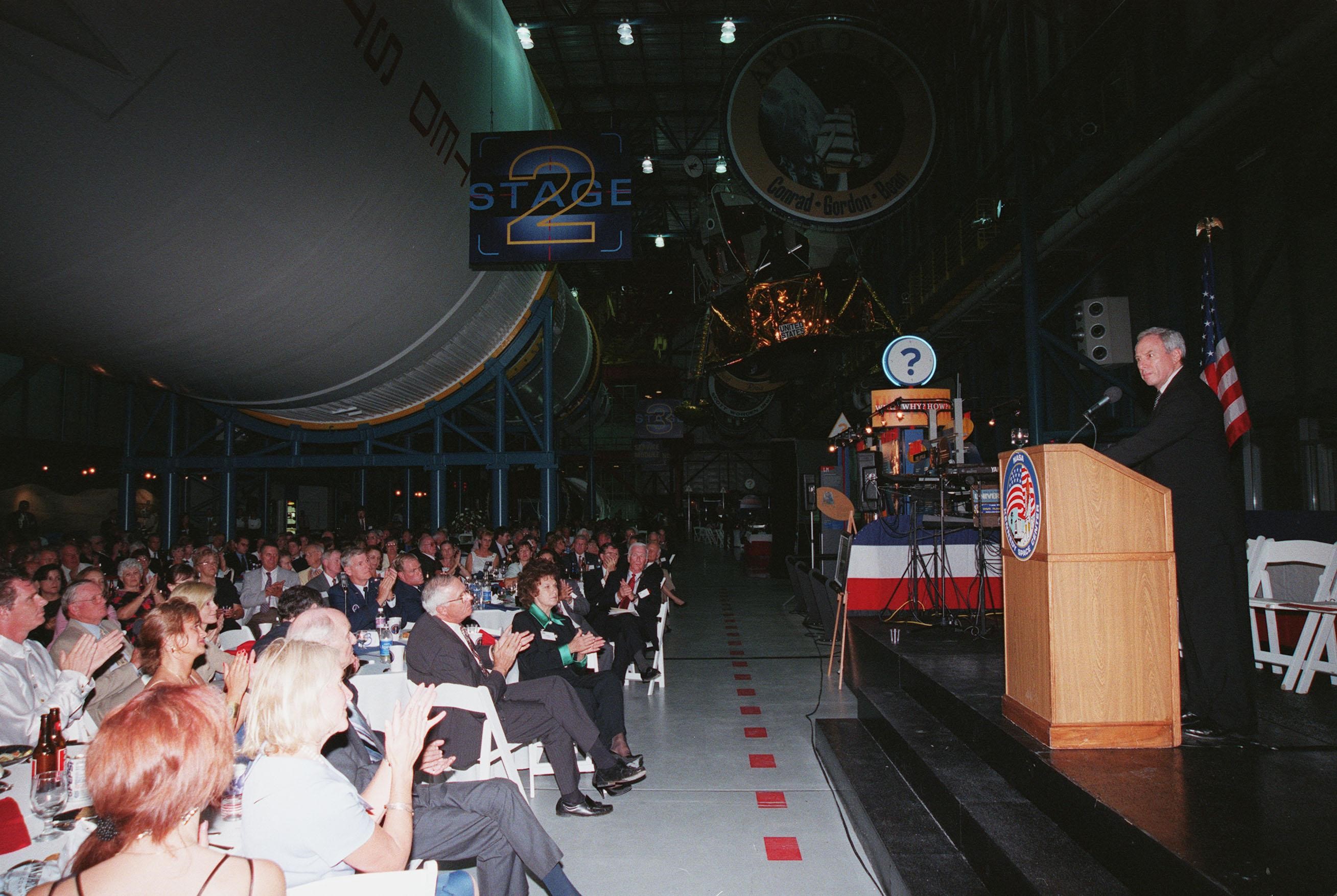 KENNEDY SPACE CENTER, FLA. -- NASA Administrator Daniel S. Goldin (right) addresses the audience at the Apollo 11 anniversary banquet honoring the Apollo team, the people who made the entire lunar landing program possible. The banquet was held in the Apollo/Saturn V Center, part of the KSC Visitor Complex, with seating under an unused Saturn V rocket like those that powered the Apollo launches . This is the 30th anniversary of the Apollo 11 launch and moon landing, July 16 and July 20, 1969. Among the guests at the banquet were former Apollo astronauts are Neil A. Armstrong and Edwin "Buzz" Aldrin who flew on Apollo 11, the launch of the first moon landing; Gene Cernan, who flew on Apollo 10 and 17 and was the last man to walk on the moon; and Walt Cunningham, who flew on Apollo 7