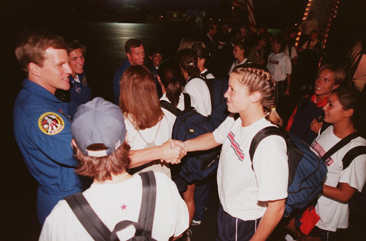 A member of the U.S. Women's World Cup Soccer Team is greeted by NASA Astronaut Scott E. Parazynski (left) upon her arrival at the Skid Strip at Cape Canaveral Air Station as her teammates look on. The team is at KSC to view the launch of Space Shuttle mission STS-93 scheduled for liftoff at 12:36 a.m. EDT July 20. Much attention has been generated over the launch due to Commander Eileen M. Collins, the first woman to serve as commander of a Shuttle mission. The primary payload of the five-day mission is the Chandra X-ray Observatory, which will allow scientists from around the world to study some of the most distant, powerful and dynamic objects in the universe. The new telescope is 20 to 50 times more sensitive than any previous X-ray telescope and is expected to unlock the secrets of supernovae, quasars and black holes