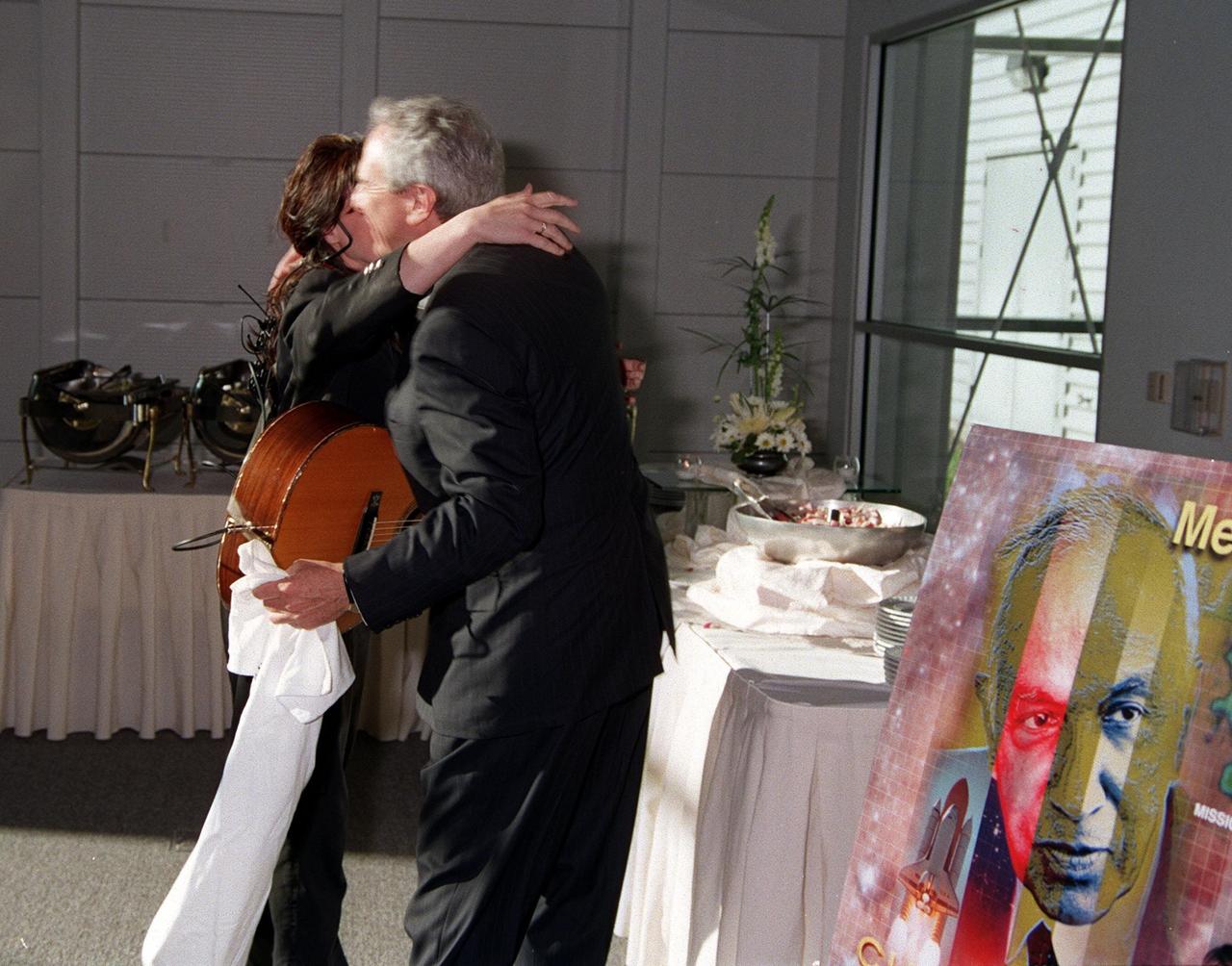KENNEDY SPACE CENTER, FLA. -- After her performance at the Apollo/Saturn V Center, country western recording artist Teresa gets a congratulatory hug from NASA Administrator Daniel Goldin. Teresa performed a song, "Brave New Girls," written for astronaut Catherine "Cady" Coleman, mission specialist on STS-93. She entertained participants and attendees of a women's forum held in the center earlier in the day. The attendees are planning to view the launch of STS-93 at the Banana Creek viewing sight. Much attention has been generated over the launch due to Commander Eileen M. Collins, the first woman to serve as commander of a Shuttle mission. Liftoff is scheduled for July 20 at 12:36 a.m. EDT