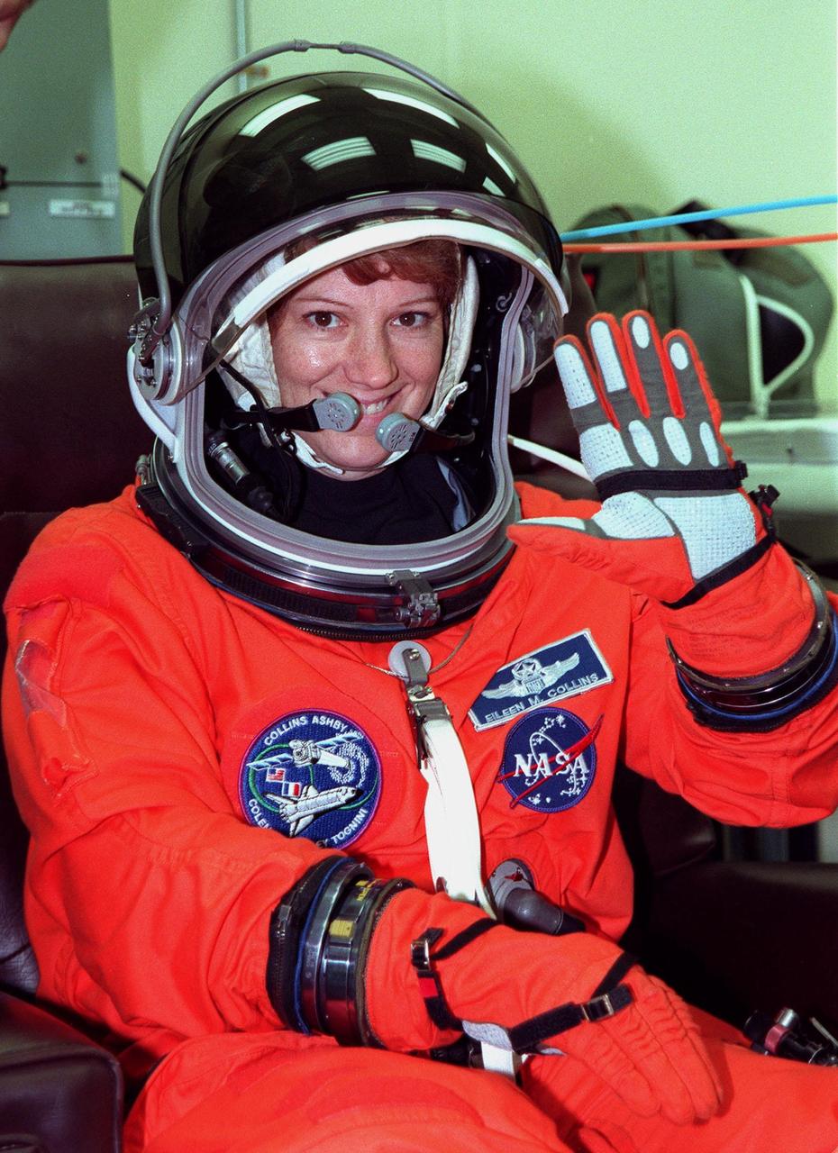 During final launch preparations in the Operations and Checkout Building, STS-93 Commander Eileen M. Collins waves after donning her launch and entry suit. After Space Shuttle Columbia's July 20 launch attempt was scrubbed at the T-7 second mark in the countdown, the launch was rescheduled for Thursday, July 22, at 12:28 a.m. EDT. The target landing date is July 26, 1999, at 11:24 p.m. EDT. STS-93 is a five-day mission primarily to release the Chandra X-ray Observatory, which will allow scientists from around the world to study some of the most distant, powerful and dynamic objects in the universe. The new telescope is 20 to 50 times more sensitive than any previous X-ray telescope and is expected unlock the secrets of supernovae, quasars and black holes. The STS-93 crew numbers five: Commander Collins, Pilot Jeffrey S. Ashby, and Mission Specialists Stephen A. Hawley (Ph.D.), Catherine G. Coleman (Ph.D.) and Michel Tognini of France, with the Centre National d'Etudes Spatiales (CNES). Collins is the first woman to serve as commander of a shuttle mission