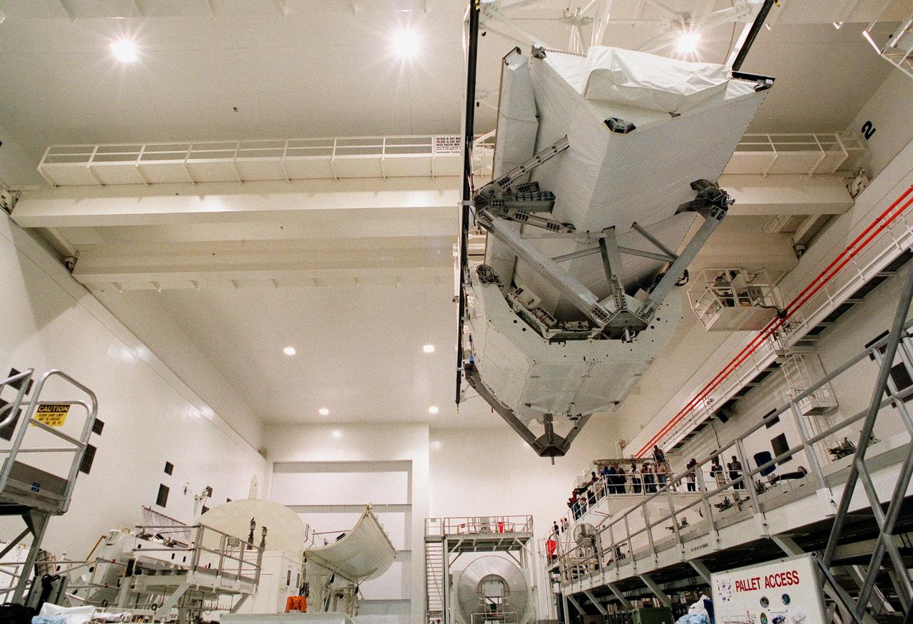 KENNEDY SPACE CENTER, FLA. -- In the Space Station Processing Facility, the Shuttle Radar Topography Mission (SRTM) clears the railing on the right as a crane moves it toward the open payload bay canister in the background (left). The canister will then be moved to the Orbiter Processing Facility and placed in the bay of the orbiter Endeavour. The SRTM consists of a specially modified radar system that will gather data for the most accurate and complete topographic map of the Earth's surface that has ever been assembled. SRTM will make use of radar interferometry, wherein two radar images are taken from slightly different locations. Differences between these images allow for the calculation of surface elevation, or change. The SRTM hardware will consist of one radar antenna in the shuttle payload bay and a second radar antenna attached to the end of a mast extended 60 meters (195 feet) out from the shuttle. STS-99 is scheduled to launch Sept. 16 at 8:47 a.m. from Launch Pad 39A