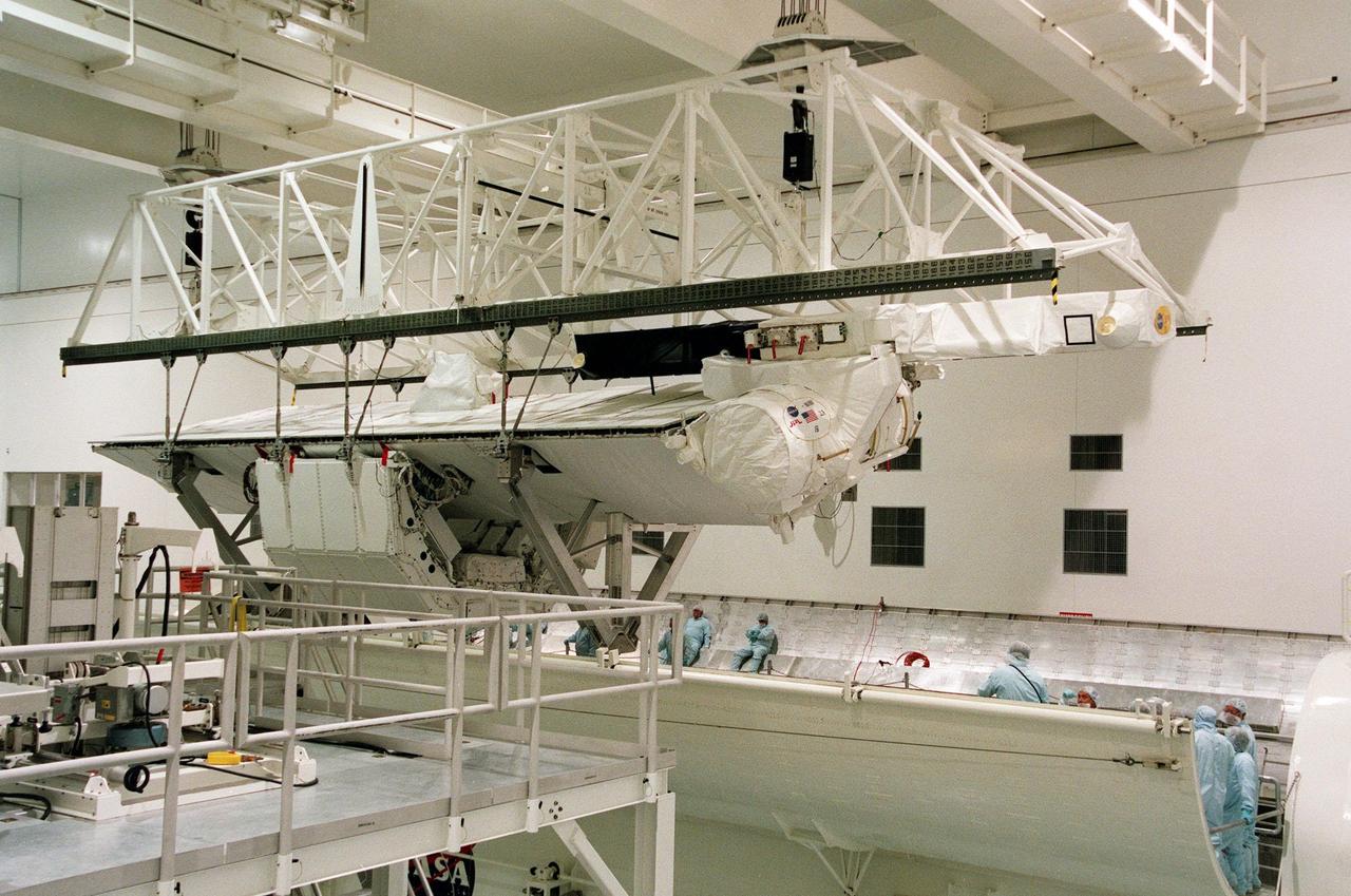 KENNEDY SPACE CENTER, FLA. -- In the Space Station Processing Facility, a crane lowers the Shuttle Radar Topography Mission (SRTM) toward the opening of the payload bay canister below. The canister will then be moved to the Orbiter Processing Facility and placed in the bay of the orbiter Endeavour. The SRTM consists of a specially modified radar system that will gather data for the most accurate and complete topographic map of the Earth's surface that has ever been assembled. SRTM will make use of radar interferometry, wherein two radar images are taken from slightly different locations. Differences between these images allow for the calculation of surface elevation, or change. The SRTM hardware will consist of one radar antenna in the shuttle payload bay and a second radar antenna attached to the end of a mast extended 60 meters (195 feet) out from the shuttle. STS-99 is scheduled to launch Sept. 16 at 8:47 a.m. from Launch Pad 39A
