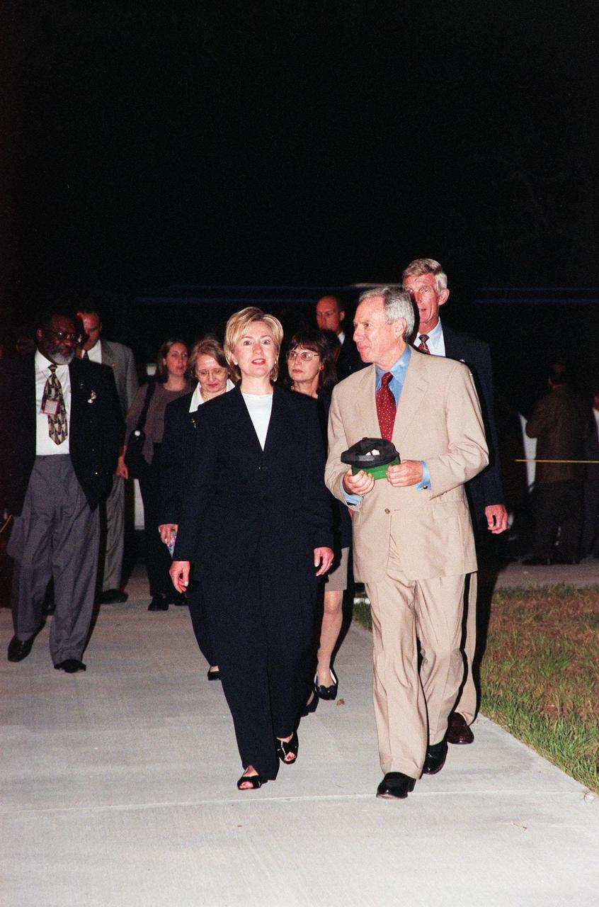 Entering the Banana Creek viewing site, First Lady Hillary Rodham Clinton is joined by NASA Administrator Daniel Goldin (right), and in the background, Deputy Director of Business Operations Jim Jennings (far left) and Director of Installation Operations Marv Jones (right, behind Goldin). Mrs. Clinton and others are at the site to watch the second launch attempt of STS-93. Moments before the first scheduled launch, July 20, STS-93 was scrubbed at the T-7 second mark in the countdown due to an indication of a high concentration of hydrogen in an aft engine compartment. The reading proved to be a false alarm. The launch was rescheduled for July 22 at 12:28 a.m. Much attention has been generated over STS-93 due to Commander Eileen M. Collins, the first woman to serve as commander of a Shuttle mission. The primary payload of the five-day mission is the Chandra X-ray Observatory, which will allow scientists from around the world to study some of the most distant, powerful and dynamic objects in the universe