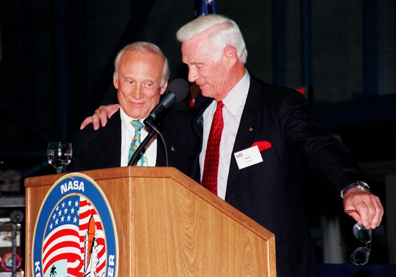 KENNEDY SPACE CENTER, FLA. -- Former Apollo astronauts Edwin "Buzz" Aldrin (left) and Gene Cernan share stories about their missions for an audience attending an anniversary banquet honoring the Apollo program team, the people who made the entire lunar landing program possible. The banquet was held in the Apollo/Saturn V Center, part of the KSC Visitor Complex. This is the 30th anniversary of the Apollo 11 launch and moon landing, July 16 and July 20, 1969. Other guests at the banquet were astronauts Wally Schirra, Gene Cernan and Walt Cunningham. Neil Armstrong was the first man to walk on the moon; Gene Cernan was the last