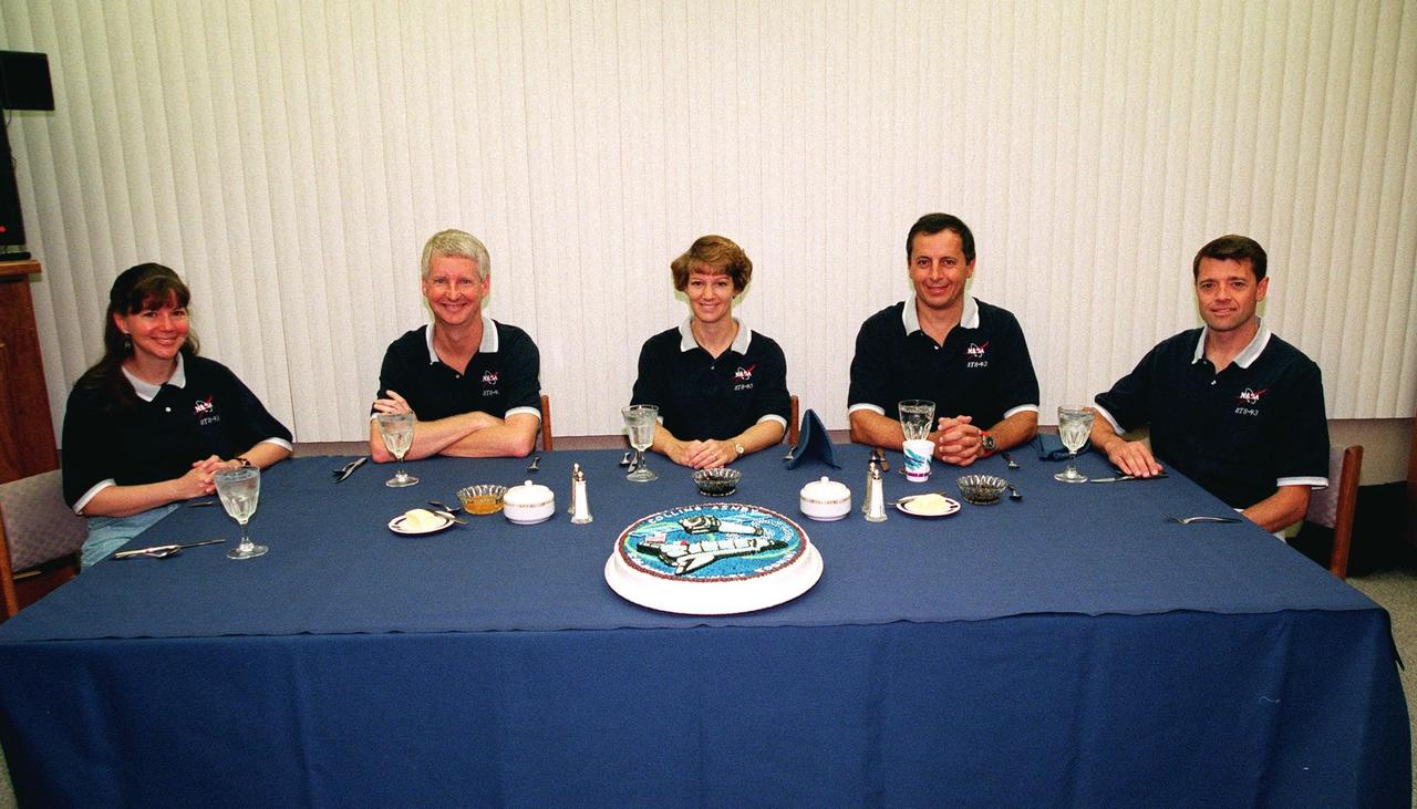 The STS-93 crew gathers a third time for a pre-launch breakfast in the Operations and Checkout Building before suiting up for launch. After Space Shuttle Columbia's July 22 launch attempt was scrubbed due to the weather, the launch was rescheduled for Friday, July 23, at 12:24 a.m. EDT. Seated from left are Mission Specialists Catherine G. Coleman (Ph.D.) and Steven A. Hawley (Ph.D.); Commander Eileen M. Collins; Mission Specialist Michel Tognini, of France, who represents the Centre National d'Etudes Spatiales (CNES); and Pilot Jeffrey S. Ashby. STS-93 is a five-day mission primarily to release the Chandra X-ray Observatory, which will allow scientists from around the world to study some of the most distant, powerful and dynamic objects in the universe. Collins is the first woman to serve as commander of a Shuttle mission. The target landing date is July 27, 1999, at 11:20 p.m. EDT