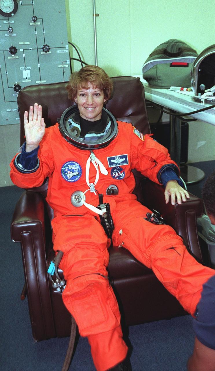 During the third launch preparations in the Operations and Checkout Building, STS-93 Commander Eileen M. Collins waves while having her launch and entry suit checked. After Space Shuttle Columbia's July 20 and 22 launch attempts were scrubbed, the launch was again rescheduled for Friday, July 23, at 12:24 a.m. EDT. STS-93 is a five-day mission primarily to release the Chandra X-ray Observatory, which will allow scientists from around the world to study some of the most distant, powerful and dynamic objects in the universe. The STS-93 crew numbers five: Commander Collins, Pilot Jeffrey S. Ashby, and Mission Specialists Steven A. Hawley (Ph.D.), Catherine G. Coleman (Ph.D.) and Michel Tognini of France, with the Centre National d'Etudes Spatiales (CNES). Collins is the first woman to serve as commander of a shuttle mission