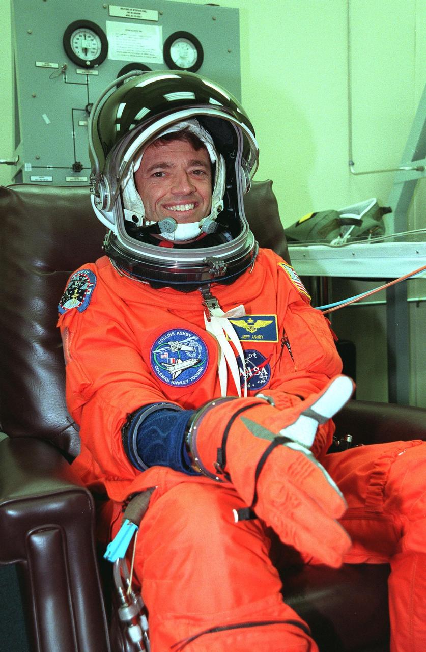 In the Operations and Checkout Building during final launch preparations for the third time, STS-93 Pilot Jeffrey S. Ashby pulls on his glove, part of his launch and entry suit. After Space Shuttle Columbia's July 20 and 22 launch attempts were scrubbed, the launch was again rescheduled for Friday, July 23, at 12:24 a.m. EDT. STS-93 is a five-day mission primarily to release the Chandra X-ray Observatory, which will allow scientists from around the world to study some of the most distant, powerful and dynamic objects in the universe. The STS-93 crew numbers five: Commander Eileen Collins, Ashby, and Mission Specialists Steven A. Hawley (Ph.D.), Catherine G. Coleman (Ph.D.) and Michel Tognini of France, with the Centre National d'Etudes Spatiales (CNES). Collins is the first woman to serve as commander of a shuttle mission