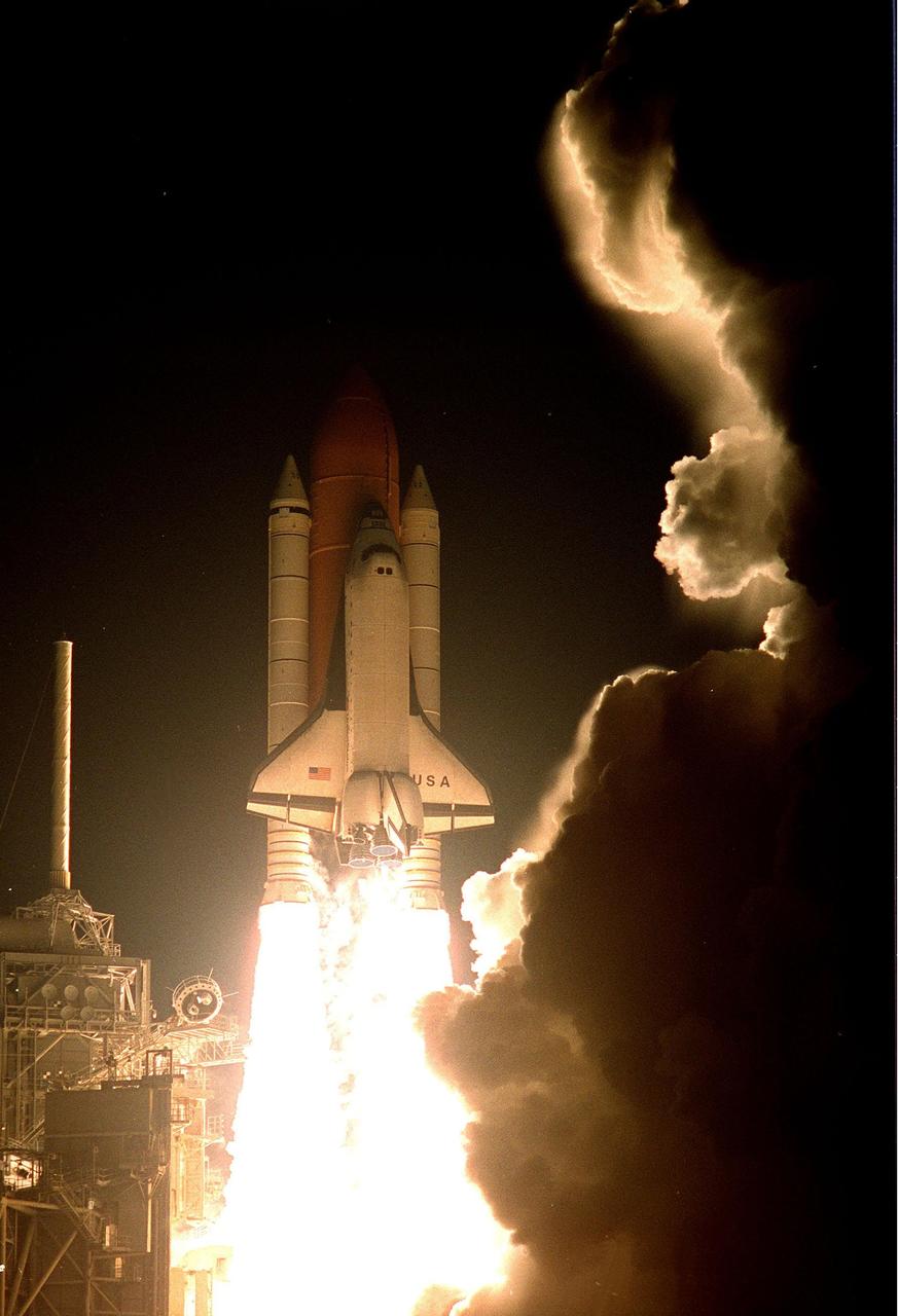 KENNEDY SPACE CENTER, FLA. -- Clouds of smoke and steam spiral away from Space Shuttle Columbia as it shoots through the night sky on its successful liftoff from Launch Pad 39-B on mission STS-93. After two unsuccessful attempts on previous nights, liftoff occurred at 12:31 a.m. EDT. STS-93 is a five-day mission primarily to release the Chandra X-ray Observatory, which will allow scientists from around the world to study some of the most distant, powerful and dynamic objects in the universe. The crew numbers five: Commander Eileen M. Collins, Pilot Jeffrey S. Ashby, and Mission Specialists Steven A. Hawley (Ph.D.), Catherine G. Coleman (Ph.D.) and Michel Tognini of France, with the Centre National d'Etudes Spatiales (CNES). The target landing date is July 27, 1999, at 11:20 p.m. EDT