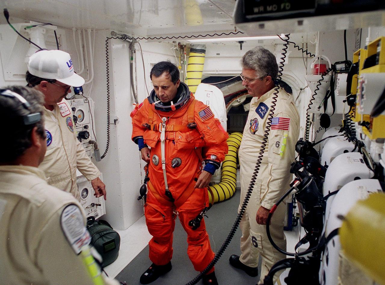 STS-93 Mission Specialist Michel Tognini of France is checked out by white room closeout crew members before entering the orbiter Columbia. Tognini is with the Centre National d'Etudes Spatiales (CNES). The white room is an environmental chamber at the end of the orbiter access arm that provides entry to the orbiter crew compartment. STS-93 is a five-day mission primarily to release the Chandra X-ray Observatory, which will allow scientists from around the world to study some of the most distant, powerful and dynamic objects in the universe. After Space Shuttle Columbia's July 20 and 22 launch attempts were scrubbed, the launch was again rescheduled for Friday, July 23, at 12:24 a.m. EDT. The target landing date is July 27 at 11:20 p.m. EDT