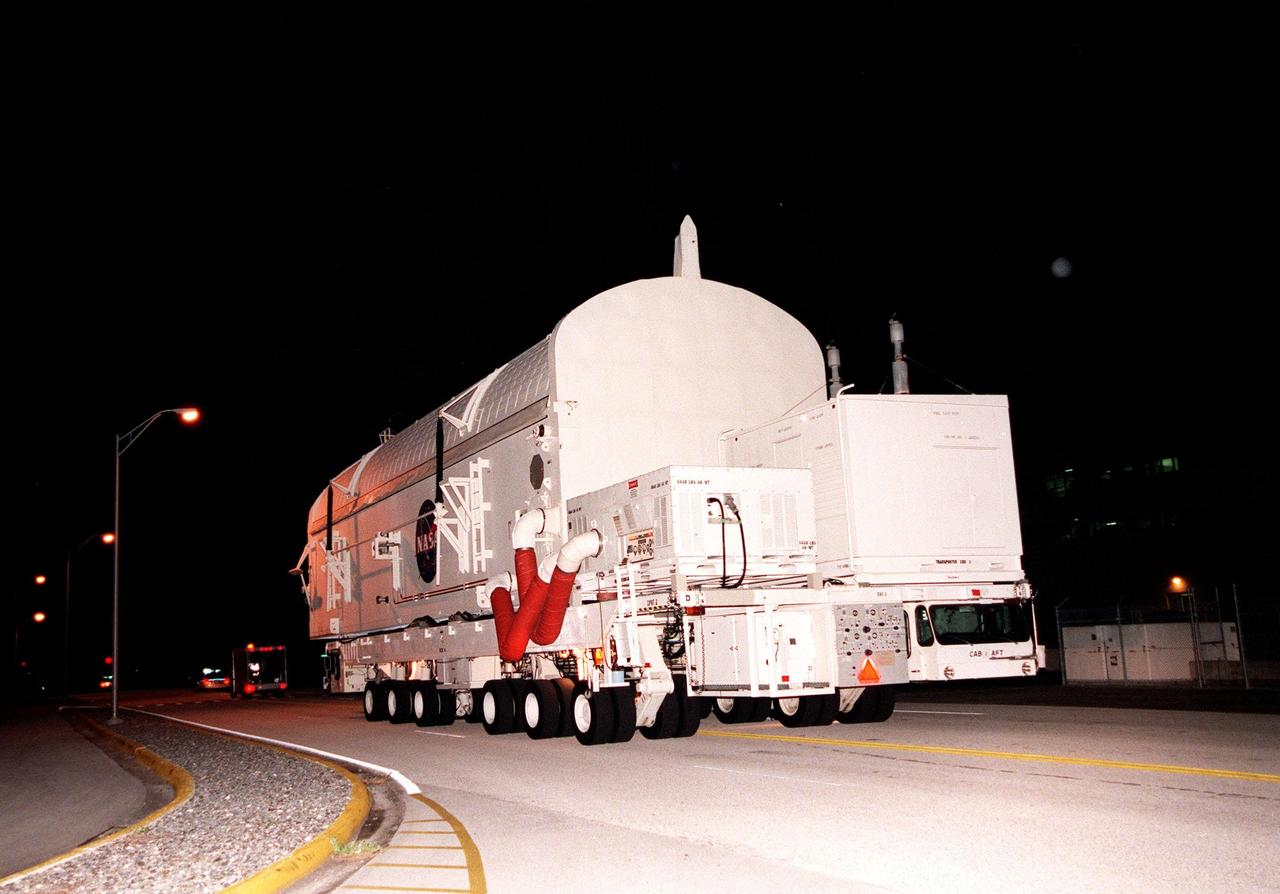 KENNEDY SPACE CENTER, FLA. -- A payload canister containing the Shuttle Radar Topography Mission (SRTM), riding atop a payload transporter, is moved from the Space Station Processing Facility to Orbiter Processing Facility (OPF) bay 2. Once there, the SRTM, the primary payload on STS-99, will be installed into the payload bay of the orbiter Endeavour. The SRTM consists of a specially modified radar system that will gather data for the most accurate and complete topographic map of the Earth's surface that has ever been assembled. SRTM will make use of radar interferometry, wherein two radar images are taken from slightly different locations. Differences between these images allow for the calculation of surface elevation. The SRTM hardware includes one radar antenna in the Shuttle payload bay and a second radar antenna attached to the end of a mast extended 60 meters (195 feet) from the shuttle. STS-99 is scheduled to launch Sept. 16 at 8:47 a.m. from Launch Pad 39A