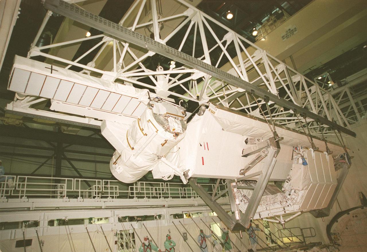 KENNEDY SPACE CENTER, FLA. -- A crane lowers the Shuttle Radar Topography Mission (SRTM), the primary payload on STS-99, into the payload bay of the orbiter Endeavour in Orbiter Processing Facility (OPF) bay 2. The SRTM consists of a specially modified radar system that will gather data for the most accurate and complete topographic map of the Earth's surface that has ever been assembled. SRTM will make use of radar interferometry, wherein two radar images are taken from slightly different locations. Differences between these images allow for the calculation of surface elevation. The SRTM hardware includes one radar antenna in the Shuttle payload bay and a second radar antenna attached to the end of a mast extended 60 meters (195 feet) from the shuttle. STS-99 is scheduled to launch Sept. 16 at 8:47 a.m. from Launch Pad 39A