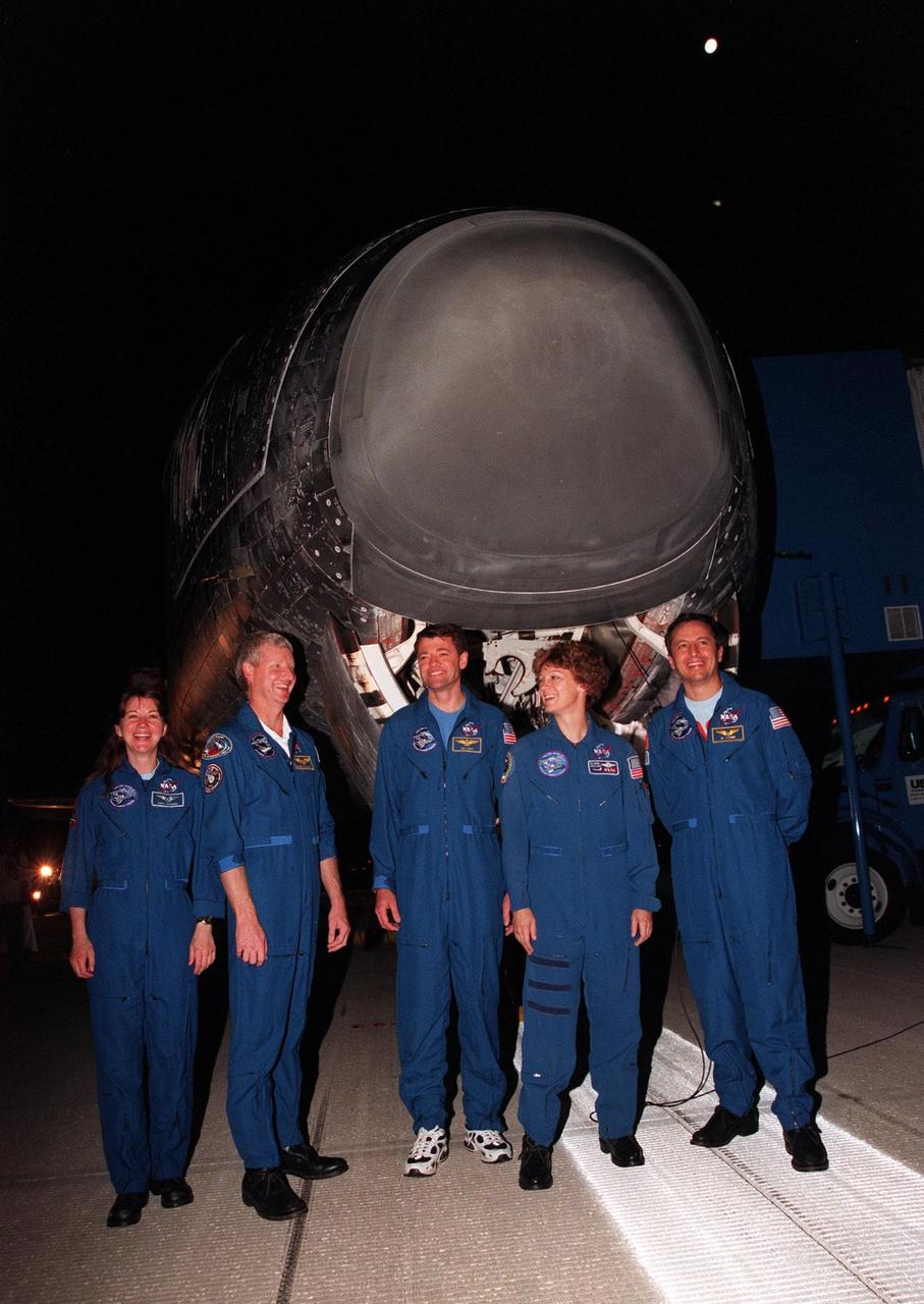 KENNEDY SPACE CENTER, FLA. -- The STS-93 crew pose in front of the Space Shuttle orbiter Columbia following their landing on runway 33 at the Shuttle Landing Facility. Main gear touchdown occurred at 11:20:35 p.m. EDT on July 27. From left to right, they are Mission Specialists Catherine G. Coleman (Ph.D.) and Steven A. Hawley (Ph.D.), Pilot Jeffrey S. Ashby, Commander Eileen Collins, and Mission Specialist Michel Tognini of France, with the Centre National d'Etudes Spatiales (CNES). The mission's primary objective was to deploy the Chandra X-ray Observatory, which will allow scientists from around the world to study some of the most distant, powerful and dynamic objects in the universe. This was the 95th flight in the Space Shuttle program and the 26th for Columbia. The landing was the 19th consecutive Shuttle landing in Florida and the 12th night landing in Shuttle program history. On this mission, Collins became the first woman to serve as a Shuttle commander