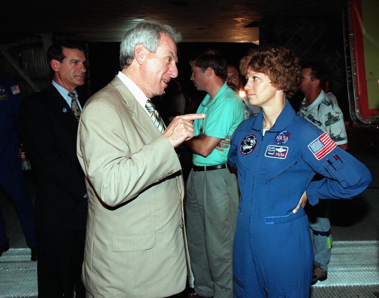 KENNEDY SPACE CENTER, FLA. -- At the Shuttle Landing Facility, NASA Administrator Daniel Goldin (foreground) talks with STS-93 Commander Eileen Collins beside the Space Shuttle orbiter Columbia following the successful completion of her mission. Marshall Space Flight Center Director Arthur G. Stephenson (far left) looks on. Landing occurred on runway 33 with main gear touchdown at 11:20:35 p.m. EDT on July 27. The mission's primary objective was to deploy the Chandra X-ray Observatory, which will allow scientists from around the world to study some of the most distant, powerful and dynamic objects in the universe. This was the 95th flight in the Space Shuttle program and the 26th for Columbia. The landing was the 19th consecutive Shuttle landing in Florida and the 12th night landing in Shuttle program history. On this mission, Collins became the first woman to serve as a Shuttle commander