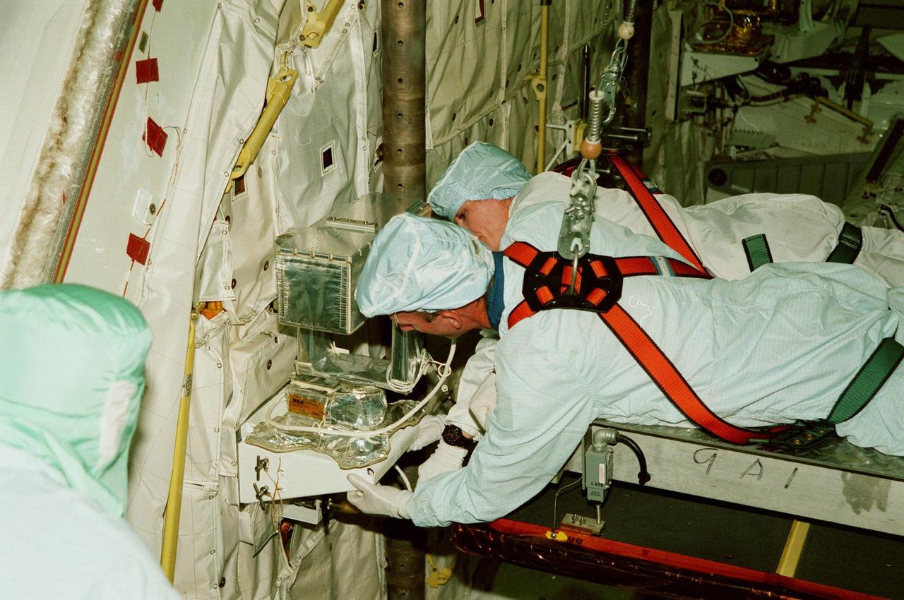 KENNEDY SPACE CENTER, FLA. -- In the Orbiter Processing Facility, STS-99 Mission Specialists Gerhard P.J. Thiele and Janet Lynn Kavandi (Ph.D.) look over part of the Shuttle Radar Topography Mission (SRTM), primary payload for their mission, as part of a Crew Equipment Interface Test (CEIT). Also taking part in the CEIT are Commander Kevin R. Kregel, Pilot Dominic L. Pudwill Gorie, and Mission Specialists Janice Voss (Ph.D.) and Mamoru Mohri. Mohri is with the National Space Development Agency (NASDA) of Japan, and Thiele is with the European Space Agency. The CEIT provides an opportunity for crew members to check equipment and facilities that will be aboard the orbiter during their mission. The SRTM is a specially modified radar system that will gather data for the most accurate and complete topographic map of the Earth's surface that has ever been assembled. SRTM will make use of radar interferometry, wherein two radar images are taken from slightly different locations. Differences between these images allow for the calculation of surface elevation, or change. The SRTM hardware will consist of one radar antenna in the shuttle payload bay and a second radar antenna attached to the end of a mast extended 60 meters (195 feet) out from the shuttle. STS-99 is scheduled to launch Sept. 16 at 8:47 a.m. from Launch Pad 39A
