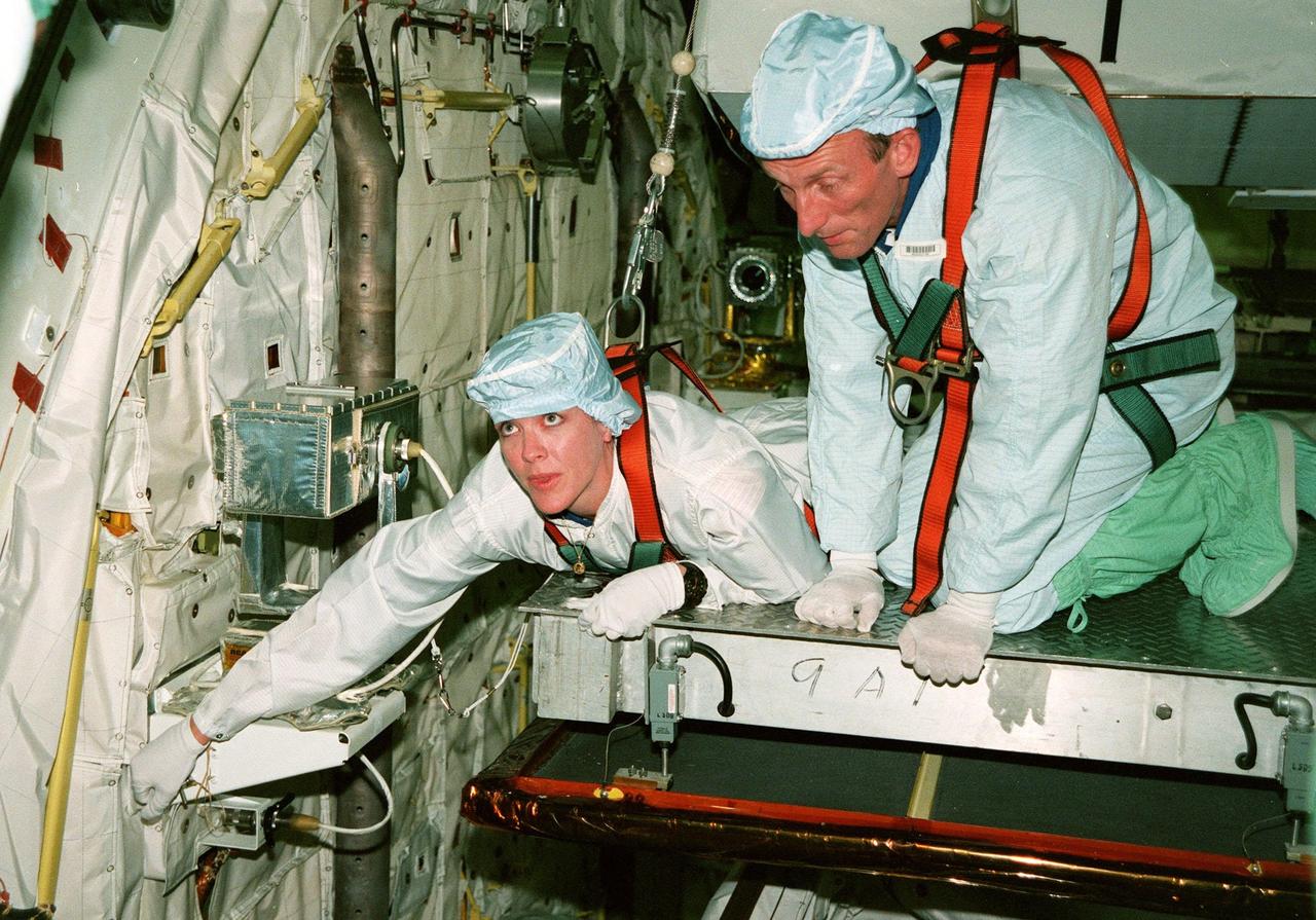 KENNEDY SPACE CENTER, FLA. -- In the Orbiter Processing Facility, STS-99 Mission Specialists Janet Lynn Kavandi (Ph.D.) and Gerhard P.J. Thiele look over part of the Shuttle Radar Topography Mission (SRTM), primary payload for their mission, as part of a Crew Equipment Interface Test (CEIT). Also taking part in the CEIT are Commander Kevin R. Kregel, Pilot Dominic L. Pudwill Gorie, and Mission Specialists Janice Voss (Ph.D.) and Mamoru Mohri. Mohri is with the National Space Development Agency (NASDA) of Japan, and Thiele is with the European Space Agency. The CEIT provides an opportunity for crew members to check equipment and facilities that will be aboard the orbiter during their mission. The SRTM is a specially modified radar system that will gather data for the most accurate and complete topographic map of the Earth's surface that has ever been assembled. SRTM will make use of radar interferometry, wherein two radar images are taken from slightly different locations. Differences between these images allow for the calculation of surface elevation, or change. The SRTM hardware will consist of one radar antenna in the shuttle payload bay and a second radar antenna attached to the end of a mast extended 60 meters (195 feet) out from the shuttle. STS-99 is scheduled to launch Sept. 16 at 8:47 a.m. from Launch Pad 39A