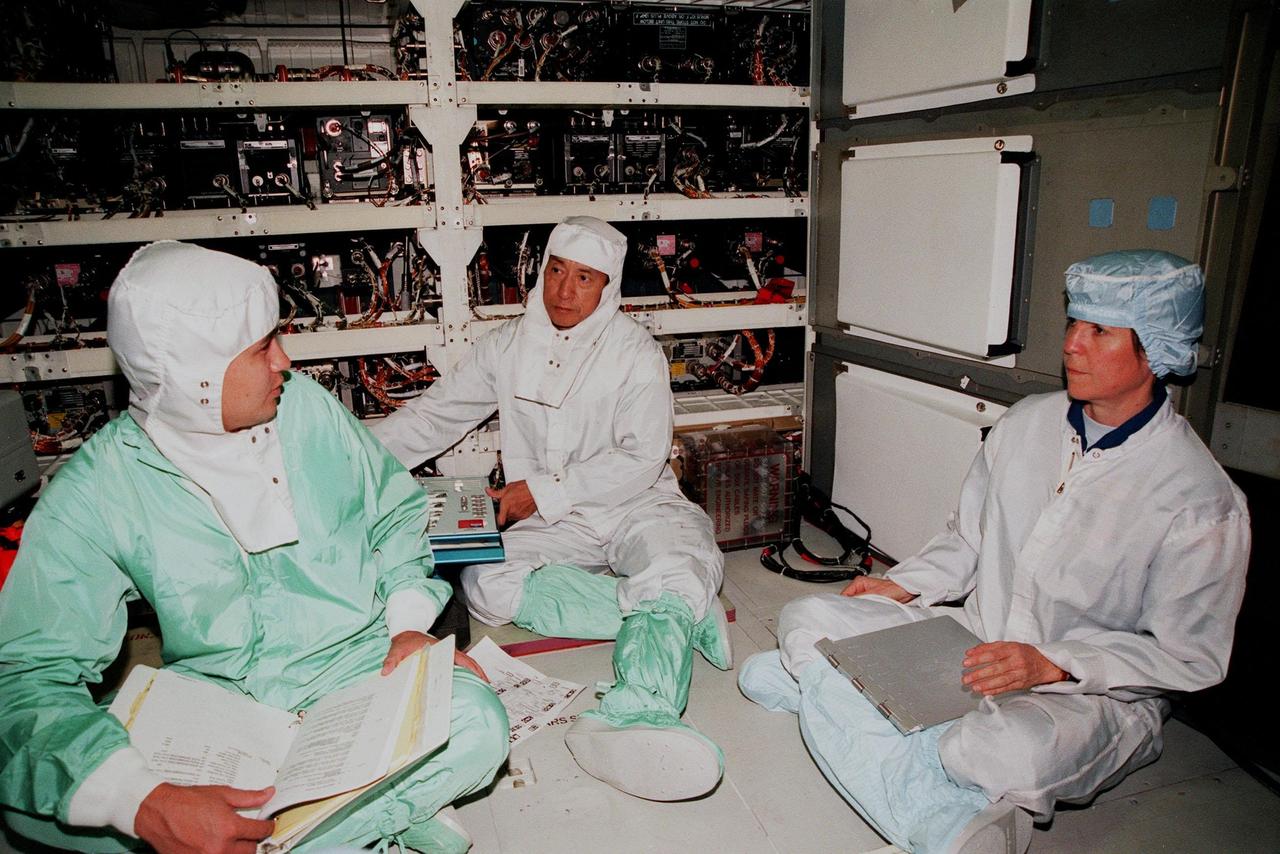 KENNEDY SPACE CENTER, FLA. -- In the Orbiter Processing Facility, STS-99 Mission Specialists Mamoru Mohri (center), who is with the National Space Development Agency (NASDA) of Japan, and Janice Voss (Ph.D.) (right) talk with a KSC worker (left) during a Crew Equipment Interface Test (CEIT). The CEIT provides an opportunity for crew members to check equipment and facilities that will be aboard the orbiter during their mission. Others taking part are Commander Kevin R. Kregel, Pilot Dominic L. Pudwill Gorie, and Mission Specialists Janet Lynn Kavandi (Ph.D.) and Gerhard P.J. Thiele, who is with the European Space Agency. The SRTM is a specially modified radar system that will gather data for the most accurate and complete topographic map of the Earth's surface that has ever been assembled. SRTM will make use of radar interferometry, wherein two radar images are taken from slightly different locations. Differences between these images allow for the calculation of surface elevation, or change. The SRTM hardware will consist of one radar antenna in the shuttle payload bay and a second radar antenna attached to the end of a mast extended 60 meters (195 feet) out from the shuttle. STS-99 is scheduled to launch Sept. 16 at 8:47 a.m. from Launch Pad 39A