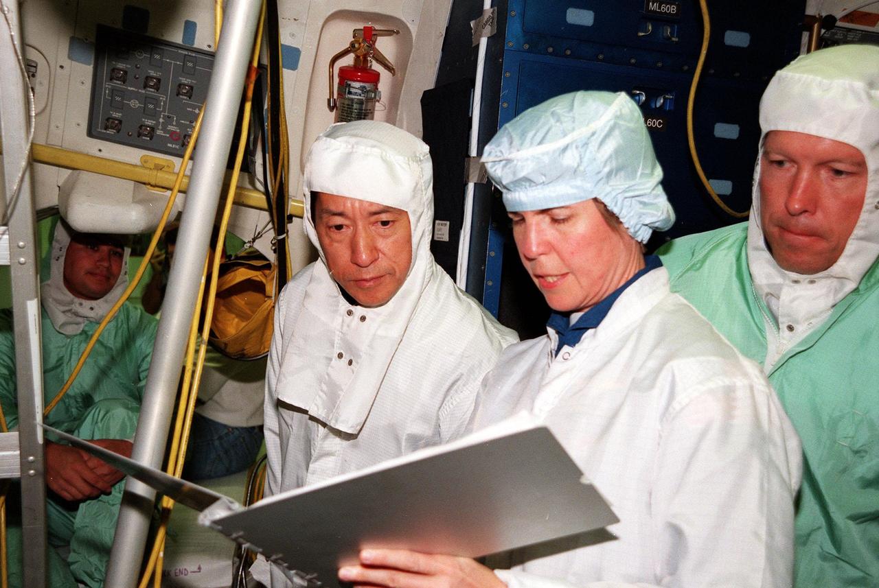 KENNEDY SPACE CENTER, FLA. -- In the Orbiter Processing Facility, STS-99 Mission Specialists Mamoru Mohri (left center), who is with the National Space Development Agency (NASDA) of Japan, and Janice Voss (Ph.D.) look over equipment during a Crew Equipment Interface Test (CEIT). The CEIT provides an opportunity for crew members to check equipment and facilities that will be aboard the orbiter during their mission. Others taking part are Commander Kevin R. Kregel, Pilot Dominic L. Pudwill Gorie, and Mission Specialists Janet Lynn Kavandi (Ph.D.) and Gerhard P.J. Thiele, who is with the European Space Agency. The SRTM is a specially modified radar system that will gather data for the most accurate and complete topographic map of the Earth's surface that has ever been assembled. SRTM will make use of radar interferometry, wherein two radar images are taken from slightly different locations. Differences between these images allow for the calculation of surface elevation, or change. The SRTM hardware will consist of one radar antenna in the shuttle payload bay and a second radar antenna attached to the end of a mast extended 60 meters (195 feet) out from the shuttle. STS-99 is scheduled to launch Sept. 16 at 8:47 a.m. from Launch Pad 39A