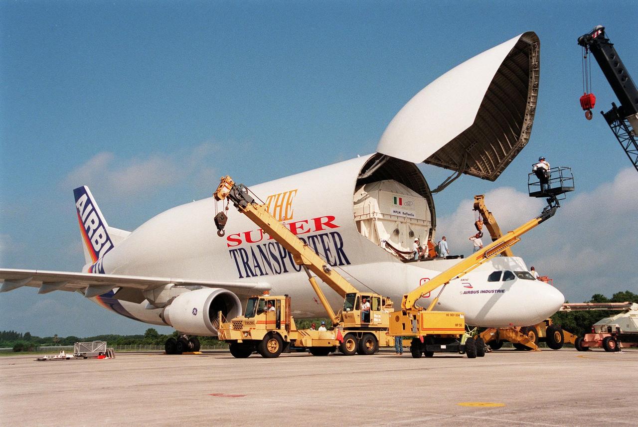KENNEDY SPACE CENTER, FLA. -- Workers on cranes circle the "Beluga" Super Transporter at the Shuttle Landing Facility, ready to help offload the Raffaello, the second Multi-Purpose Logistics Module (MPLM) for the International Space Station (ISS). One of Italy's major contributions to the ISS program, the MPLM is a reusable logistics carrier and the primary delivery system used to resupply and return station cargo requiring a pressurized environment. Weighing nearly 4.5 tons, the module measures 21 feet long and 15 feet in diameter. Raffaello will join Leonardo, the first Italian-built MPLM, in the Space Station Processing Facility for testing. NASA, Boeing, the Italian Space Agency and Alenia Aerospazio will provide engineering support