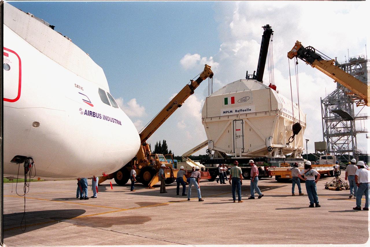 KENNEDY SPACE CENTER, FLA. -- Cranes supporting the Multi-Purpose Logistics Module (MPLM) called Raffaello lower it onto a transporter for transfer to the Space Station Processing Facility (SSPF). At the SSPF the Raffaello will undergo testing, joining the first Italian-built MPLM, Leonardo. One of Italy's major contributions to the ISS program, the MPLM is a reusable logistics carrier and the primary delivery system used to resupply and return station cargo requiring a pressurized environment. Weighing nearly 4.5 tons, the Raffaello measures 21 feet long and 15 feet in diameter. Raffaello is scheduled to be launched on mission STS-100 July 27, 2000