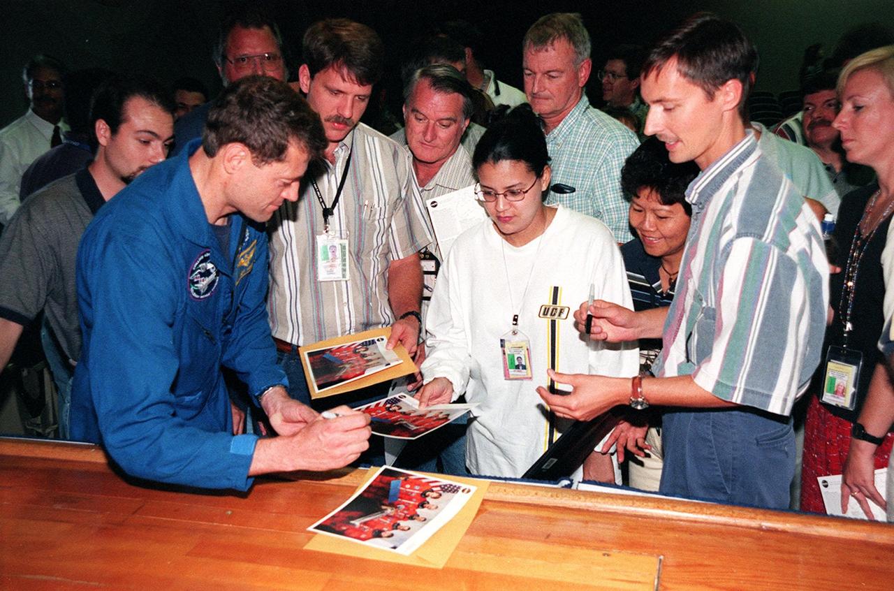 STS-93 Pilot Jeffrey S. Ashby signs autographs after a mission presentation for KSC employees. The five-day mission primarily released the Chandra X-ray Observatory, allowing scientists from around the world to study some of the most distant, powerful and dynamic objects in the universe. Chandra is expected to provide unique and crucial information on the nature of objects ranging from comets in our solar system to quasars at the edge of the observable universe. Since X-rays are absorbed by the Earth's atmosphere, space-based observatories are necessary to study these phenomena and allow scientists to analyze some of the greatest mysteries of the universe. STS-93 was also the first mission to have a woman, Eileen M. Collins, serving as Shuttle commander