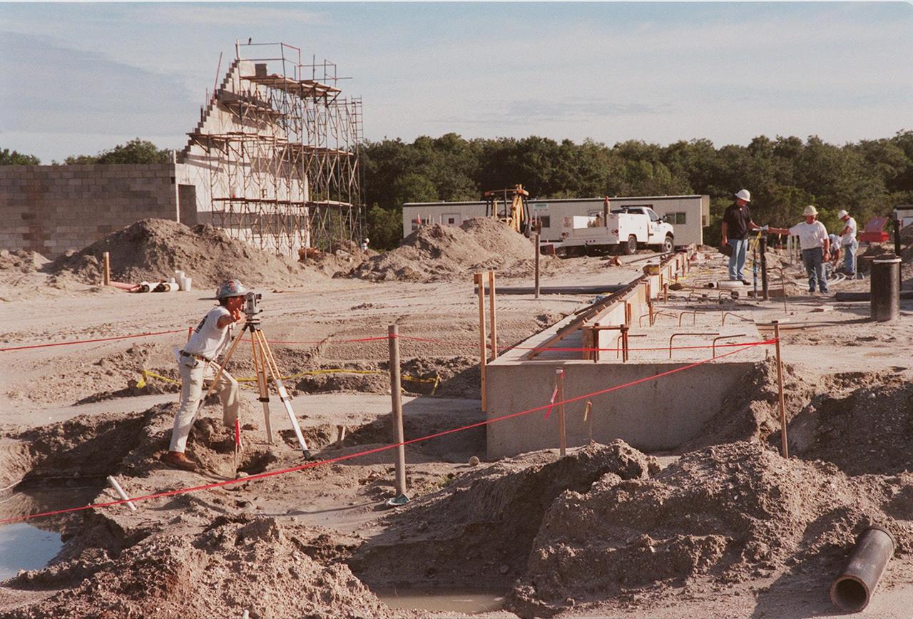 At the construction site of the Reusable Launch Vehicle (RLV) complex at KSC, workers take measurements for one of the buildings. Located near the Shuttle Landing Facility, the complex will include facilities for related ground support equipment and administrative/ technical support. It will be available to accommodate the Space Shuttle; the X-34 RLV technology demonstrator; the L-1011 carrier aircraft for Pegasus and X-34; and other RLV and X-vehicle programs. The complex is jointly funded by the Spaceport Florida Authority, NASA's Space Shuttle Program and KSC. The facility will be operational in early 2000