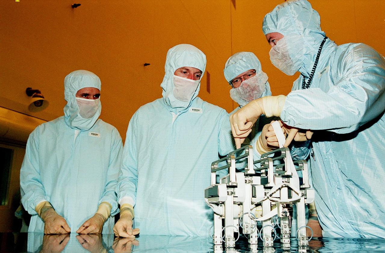 In the Payload Hazardous Servicing Facility, members of the STS-103 crew get instructions on use of rib clamps for the Shield Shell Replacement Fabric (SSRF) task on repair of the Hubble Space Telescope. The seven-member crew are Commander Curtis L. Brown Jr., Pilot Scott J. Kelly, and Mission Specialists Steven L. Smith, C. Michael Foale (Ph.D.), John M. Grunsfeld (Ph.D.), Claude Nicollier of Switzerland, and Jean-François Clervoy of France. Nicollier and Clervoy are with the European Space Agency. Mission STS-103 is a "call-up" due to the need to replace portions of the pointing system, the gyros, which have begun to fail on the Hubble Space Telescope. Although Hubble is operating normally and conducting its scientific observations, only three of its six gyroscopes are working properly. The gyroscopes allow the telescope to point at stars, galaxies and planets. The STS-103 crew will not only replace gyroscopes, it will also replace a Fine Guidance Sensor, an older computer with a new enhanced model, an older data tape recorder with a solid state digital recorder, a failed spare transmitter with a new one, and degraded insulation on the telescope with new thermal insulation. The crew will also install a Battery Voltage/Temperature Improvement Kit to protect the spacecraft batteries from overcharging and overheating when the telescope goes into a safe mode. The scheduled launch date in October is under review