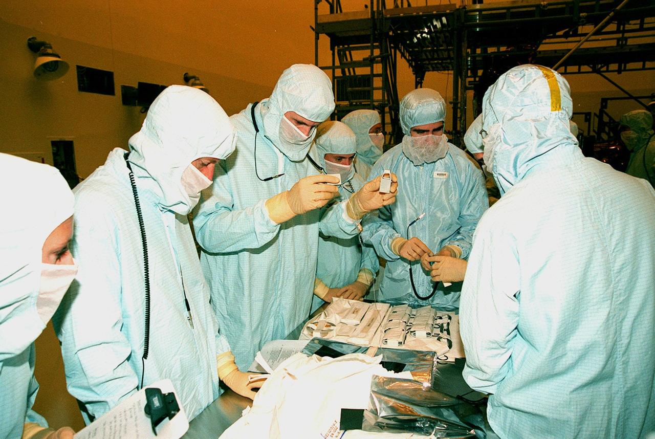 In the Payload Hazardous Servicing Facility, members of the STS-103 crew look at some of the equipment to be used during their mission. The seven-member crew are Commander Curtis L. Brown Jr., Pilot Scott J. Kelly, and Mission Specialists Steven L. Smith, C. Michael Foale (Ph.D.), John M. Grunsfeld (Ph.D.), Claude Nicollier of Switzerland, and Jean-François Clervoy of France. Nicollier and Clervoy are with the European Space Agency. Mission STS-103 is a "call-up" due to the need to replace portions of the pointing system, the gyros, which have begun to fail on the Hubble Space Telescope. Although Hubble is operating normally and conducting its scientific observations, only three of its six gyroscopes are working properly. The gyroscopes allow the telescope to point at stars, galaxies and planets. The STS-103 crew will not only replace gyroscopes, it will also replace a Fine Guidance Sensor and an older computer with a new enhanced model, an older data tape recorder with a solid state digital recorder, a failed spare transmitter with a new one, and degraded insulation on the telescope with new thermal insulation. The crew will also install a Battery Voltage/Temperature Improvement Kit to protect the spacecraft batteries from overcharging and overheating when the telescope goes into a safe mode. The scheduled launch date in October is under review