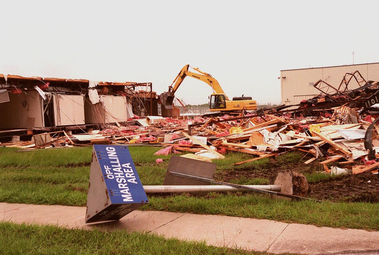 The walls of the Butler Building at Kennedy Space Center come tumbling down, with the help of the crane in the background. The building, which is near the Orbiter Processing Facility, is being demolished in order to extend the crawlerway leading to the high bay of the Vehicle Assembly Building (VAB), part of KSC's Safe Haven project. The goal of Safe Haven is to strengthen readiness for Florida's hurricane season by expanding the VAB's storage capacity. Construction includes outfitting the VAB with a third stacking area, in high bay 2, that will allow NASA to preassemble stacks and still have room in the VAB to pull a Shuttle back from the pad into the safety of the VAB if severe weather threatens. The VAB can withstand winds up to 125 mph