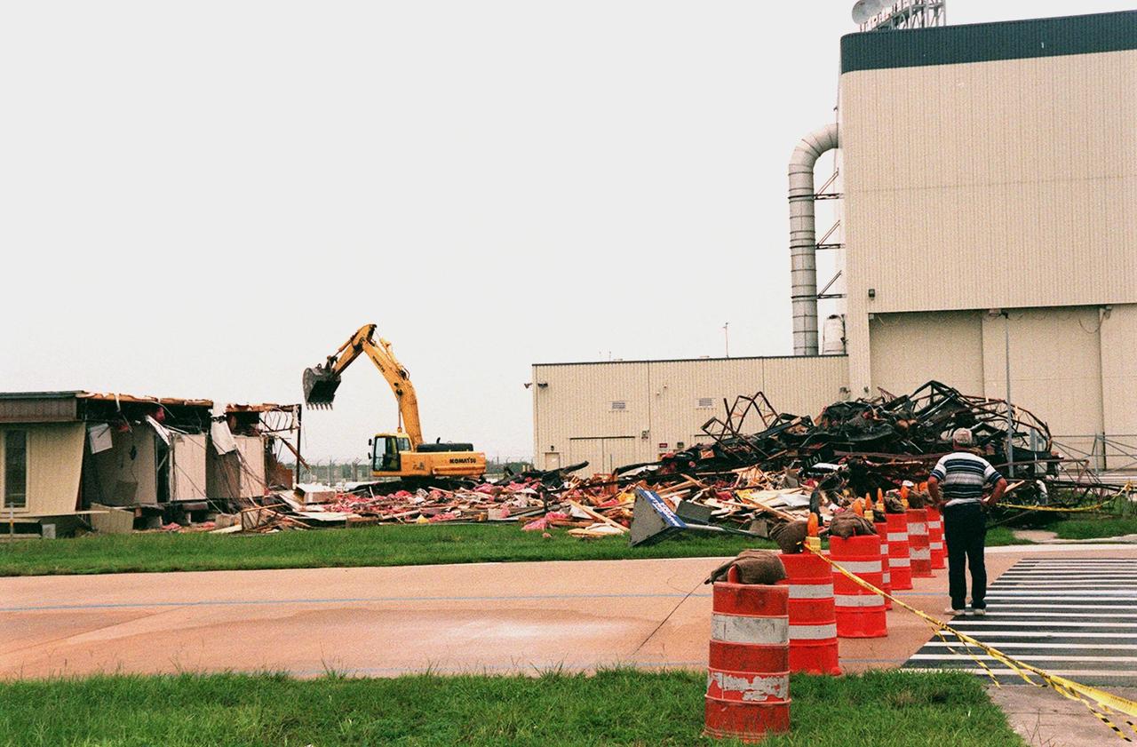 The Butler Building at Kennedy Space Center is nearly demolished, with the help of the crane in the background. The building, which is near the Orbiter Processing Facility (right), is being demolished in order to extend the crawlerway leading to the high bay of the Vehicle Assembly Building (VAB), part of KSC's Safe Haven project. The goal of Safe Haven is to strengthen readiness for Florida's hurricane season by expanding the VAB's storage capacity. Construction includes outfitting the VAB with a third stacking area, in high bay 2, that will allow NASA to preassemble stacks and still have room in the VAB to pull a Shuttle back from the pad into the safety of the VAB if severe weather threatens. The VAB can withstand winds up to 125 mph